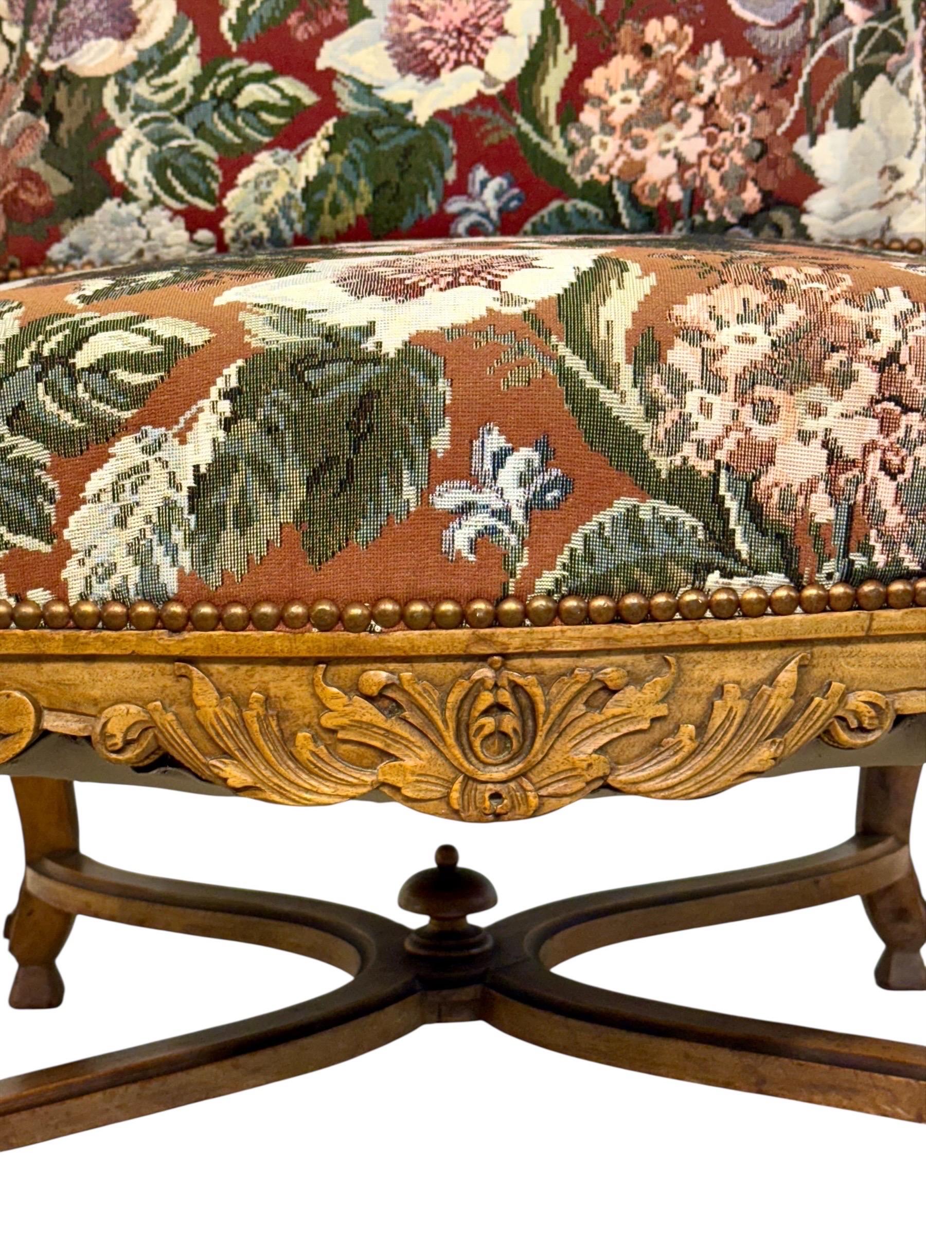 Questa poltrona francese, realizzata in noce massiccio nel XIX secolo, è un raffinato esempio del duraturo stile Luigi XV. Con le sue curve aggraziate, gli intricati intagli e la seduta e lo schienale riccamente imbottiti, incarna l'eleganza e la