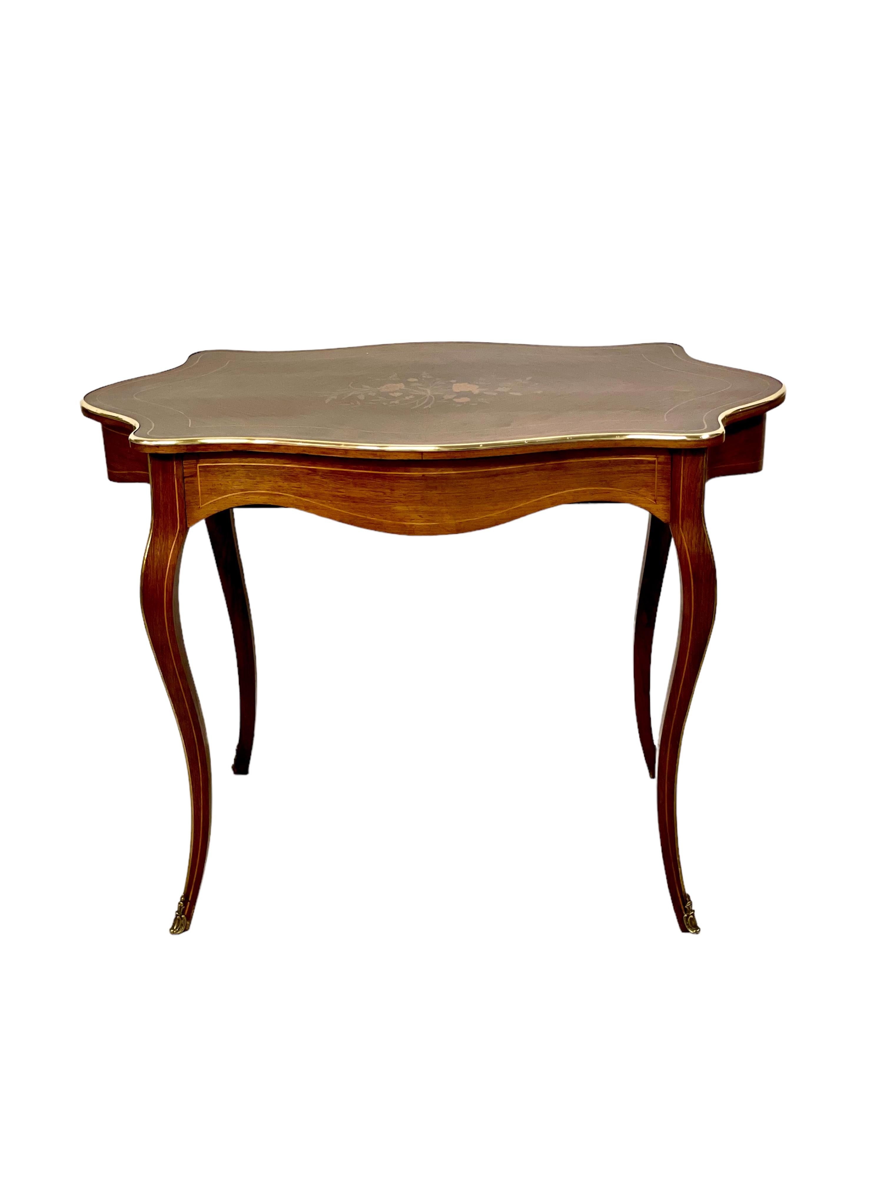 Très élégant bureau ou table centrale de style Louis XV, avec une marqueterie florale gracieusement ornée et des bordures complexes sur le plateau, révélant un seul tiroir et des pieds élégamment courbés dans le style Louis XV. 
Cette table exquise