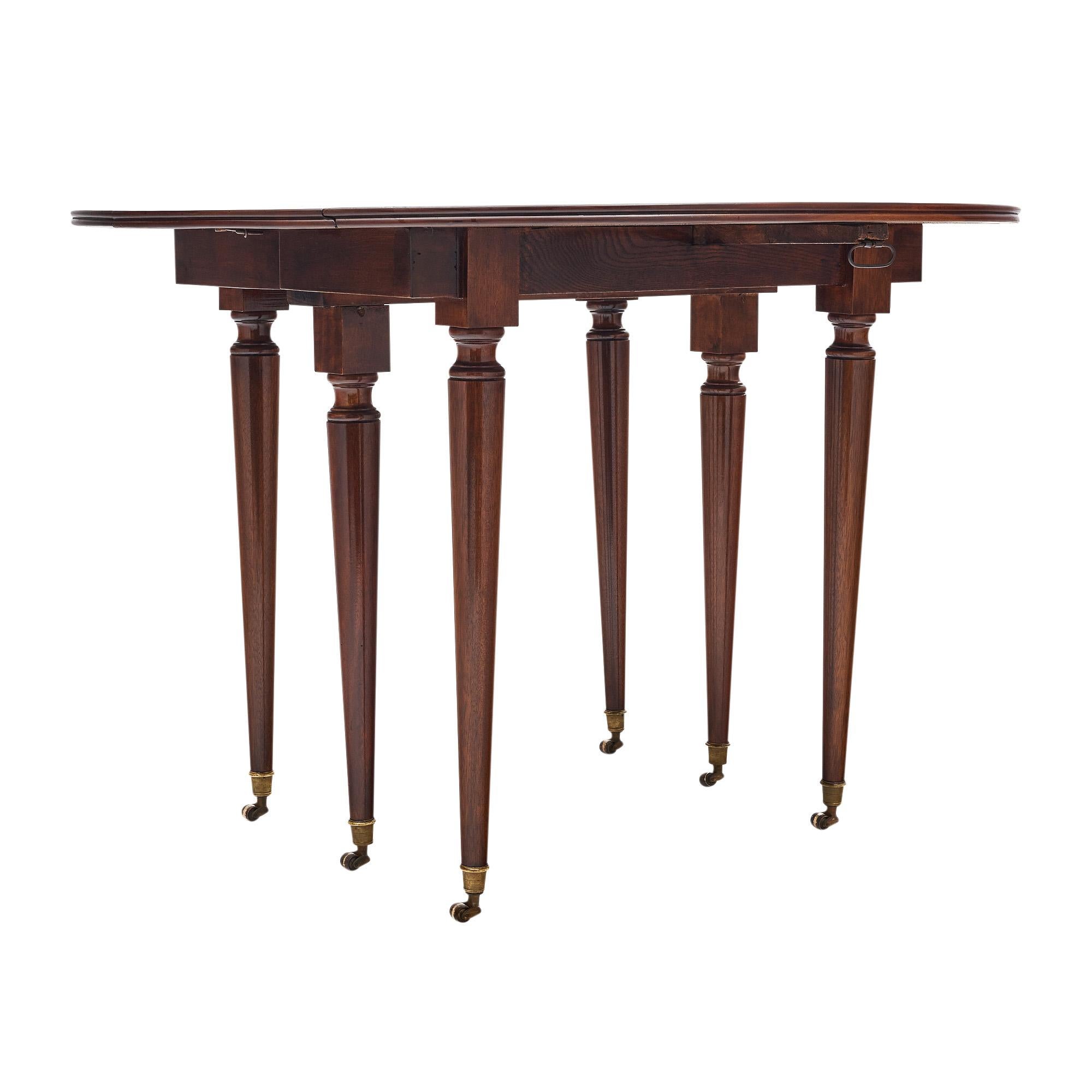 Table de salle à manger française de style Louis XVI. Cette pièce est fabriquée en bois massif, principalement en acajou. Il est fini avec un polissage français lustré de qualité muséale. Six pieds tournés soutiennent le plateau ovale extensible. Il