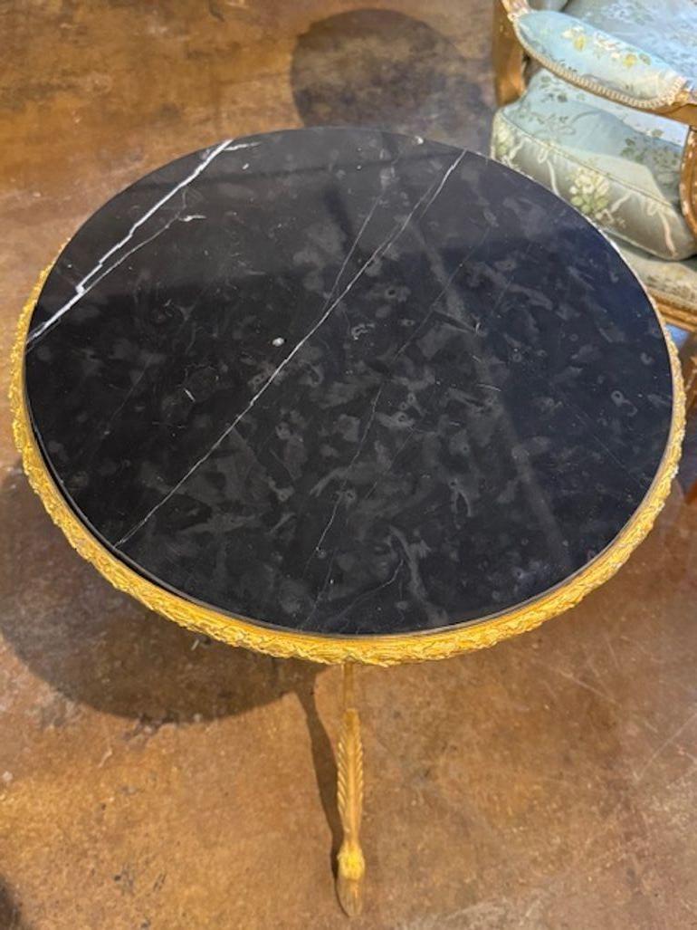 Este producto es una estilizada y elegante mesa auxiliar Luis XVI del siglo XIX de bronce y mármol negro. La mesa presenta una base decorativa de bronce dorado con una tapa de mármol pulido. Añade un auténtico toque de sofisticación a cualquier