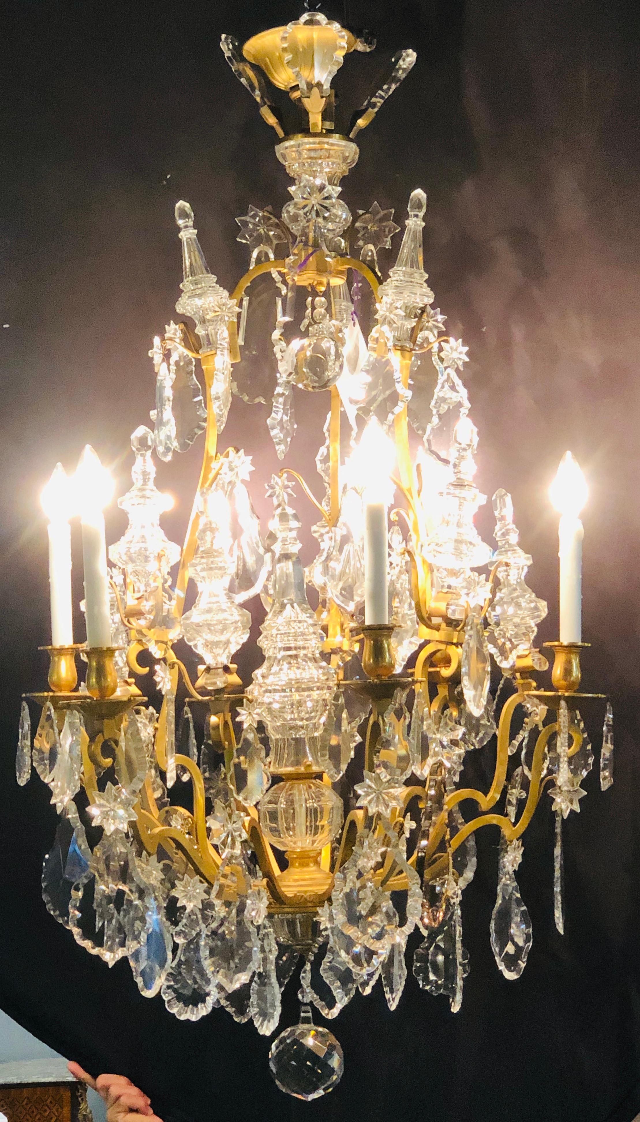 19th century bronze and large crystal palatial chandelier. A monumental impressive chandelier of bronze form with center glass column-form and large glass prisms. The style and form of this one of a kind chandelier is simply stunning with to much to