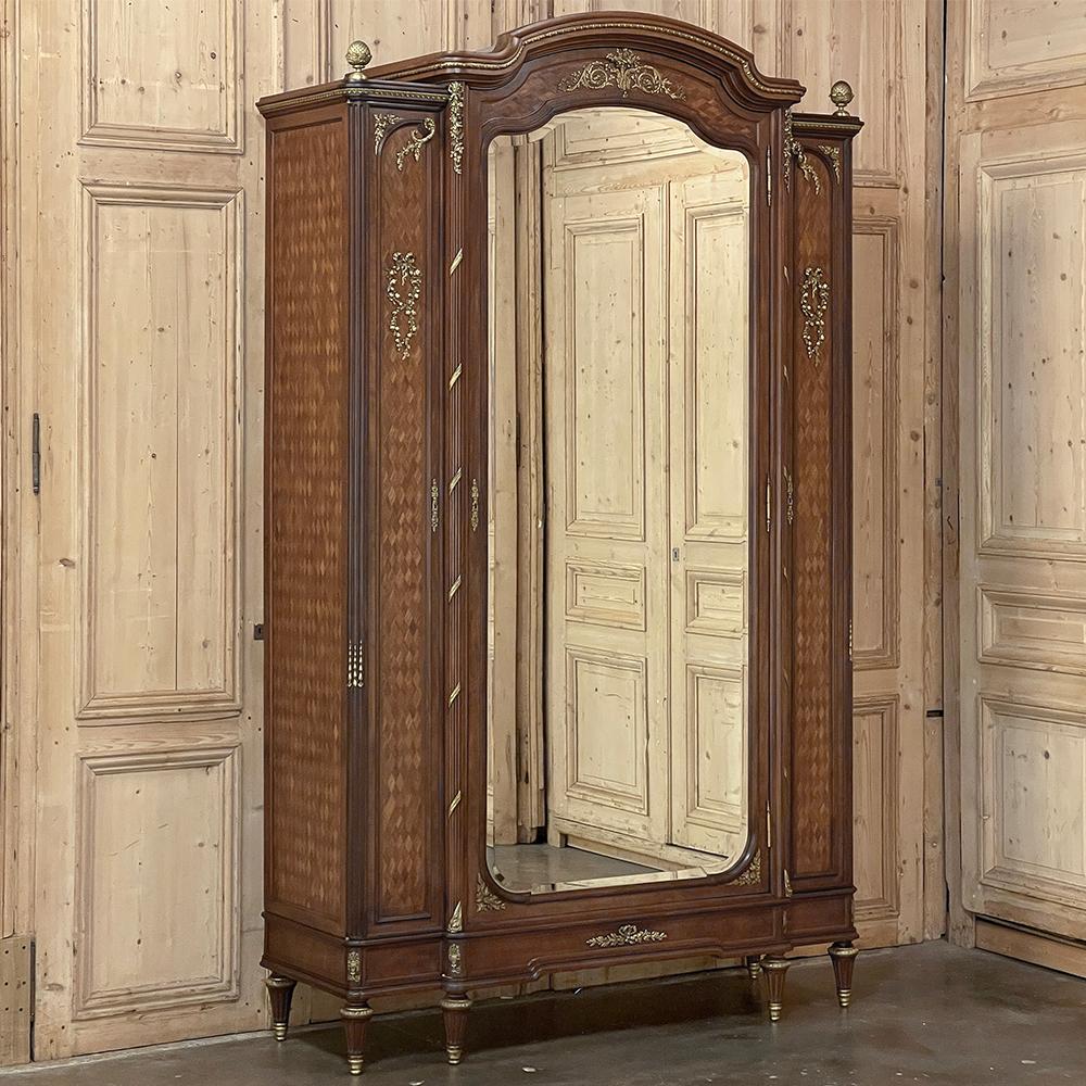 19th Century Louis XVI Bronze Mounted Mahogany Armoire by Schmit of Paris is an example of the Belle Epoque magnificence that gained France worldwide recognition at the end of the 19th century.  Founded in 1818, Schmit was at the forefront of what