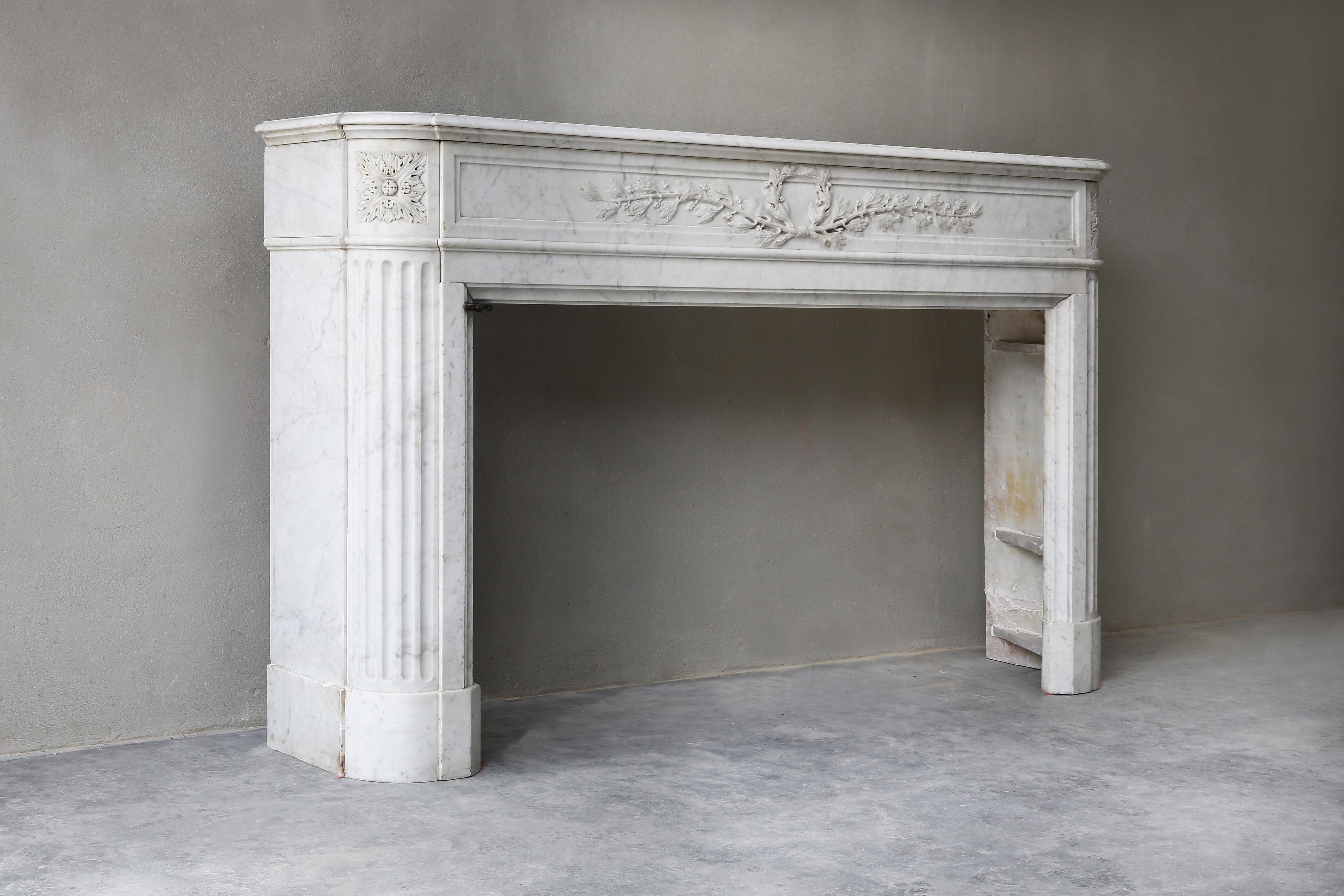 Exclusive antique marble fireplace made of Carrara marble! A beautiful item within our collection. This fireplace is in the style of Louis XVI and dates from the 19th century. The front part is decorated with ornaments and lines and the legs are