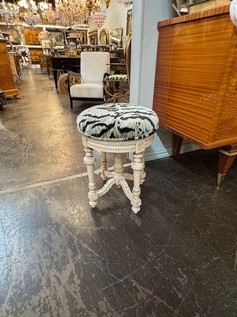 Este escabel del siglo XIX es una impresionante pieza de estilo Luis XVI, con intrincadas tallas que muestran una exquisita artesanía. El reposapiés está pintado, lo que añade un toque de elegancia a su diseño antiguo. Tapizada en un bonito tejido