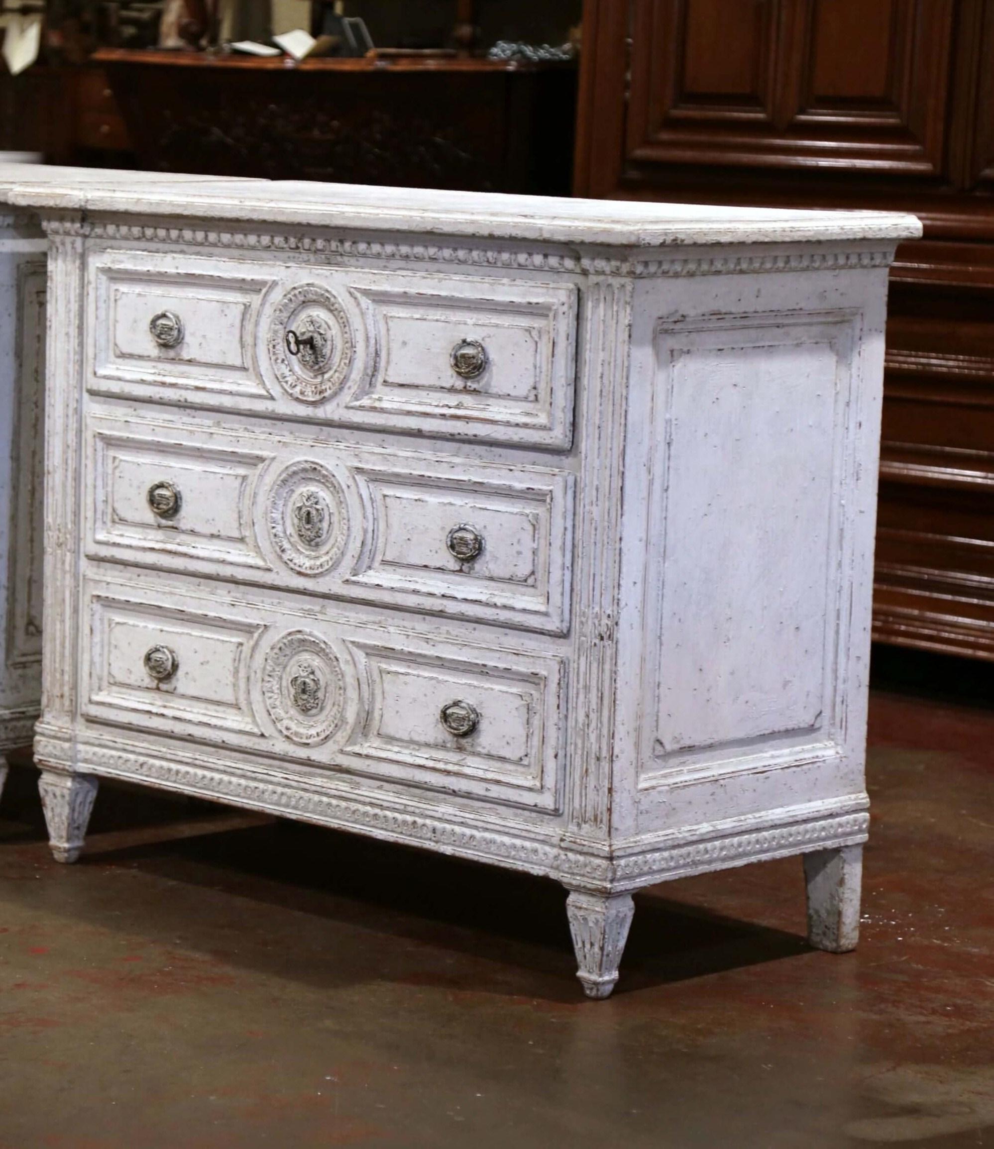 Use this elegant painted chest of drawers in an entry way or living room. Crafted in France, circa 1860, this cabinet sits on tapered and fluted feet, and features detailed carved decor including a round center medallion on each drawer, and spline