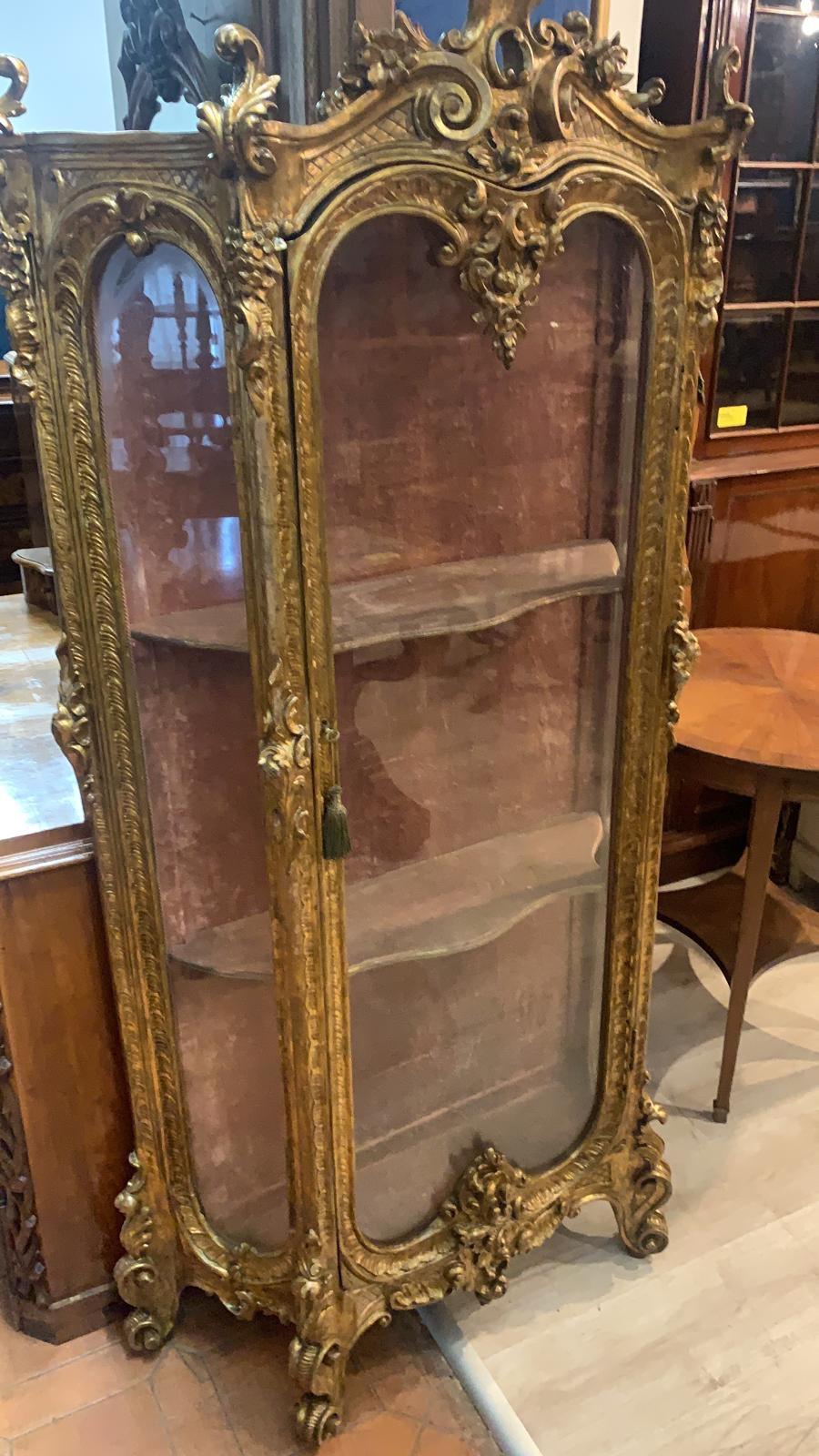 French display cabinet, of great quality, entirely made of wood carved and gilded in pure gold. Finely carved and with harmonious shapes that make it elegant and never too pompous. Extremely small in size to be easily placed anywhere in your