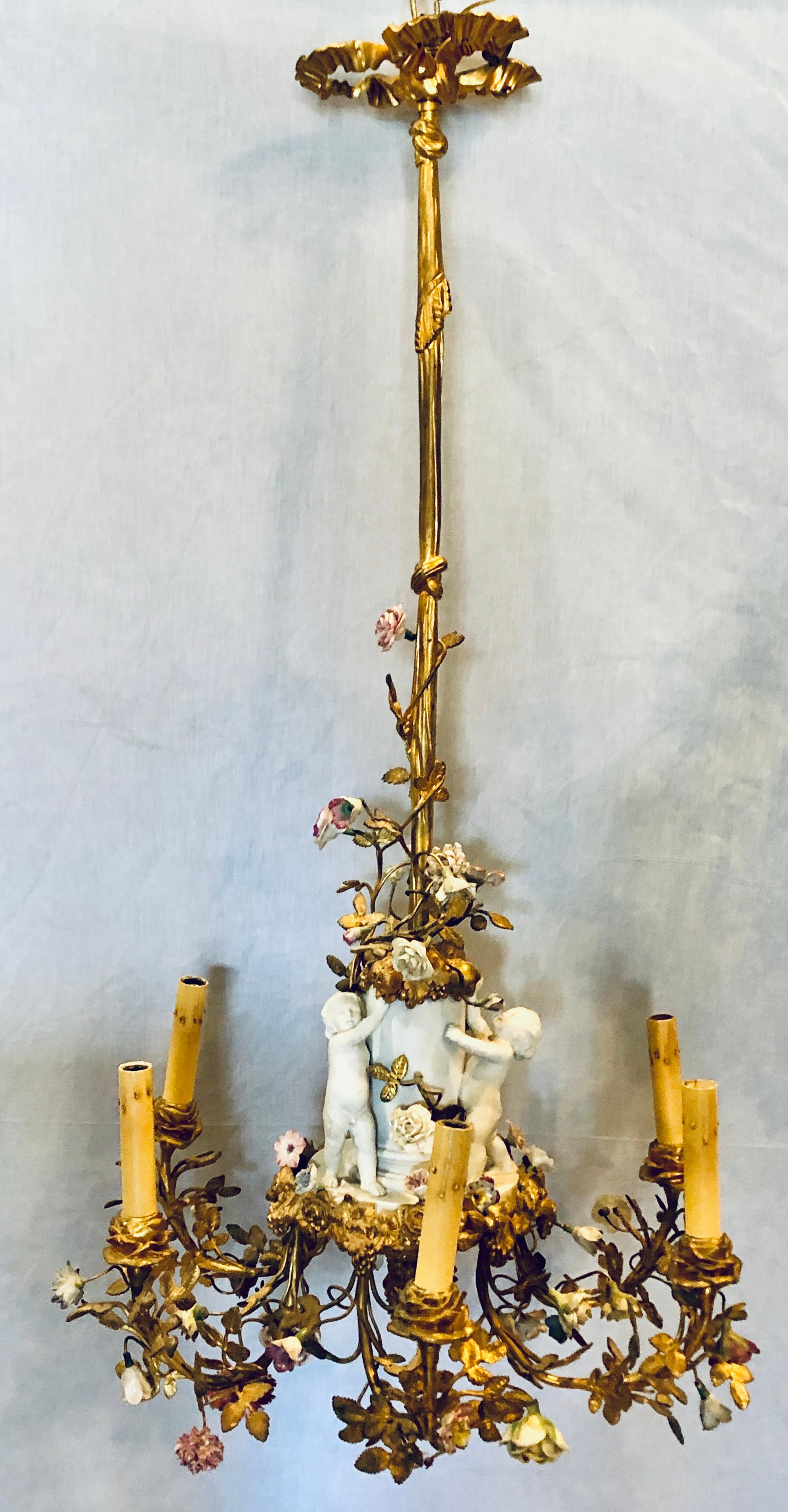 19th century gilt bronze and Meissen with a Sevres Parian figural centerpiece chandelier. This finely cast dore bronze chandelier has a long Louis XVI rod with a ribbon bow canopy supporting a sevres parian center piece having dancing cherubs