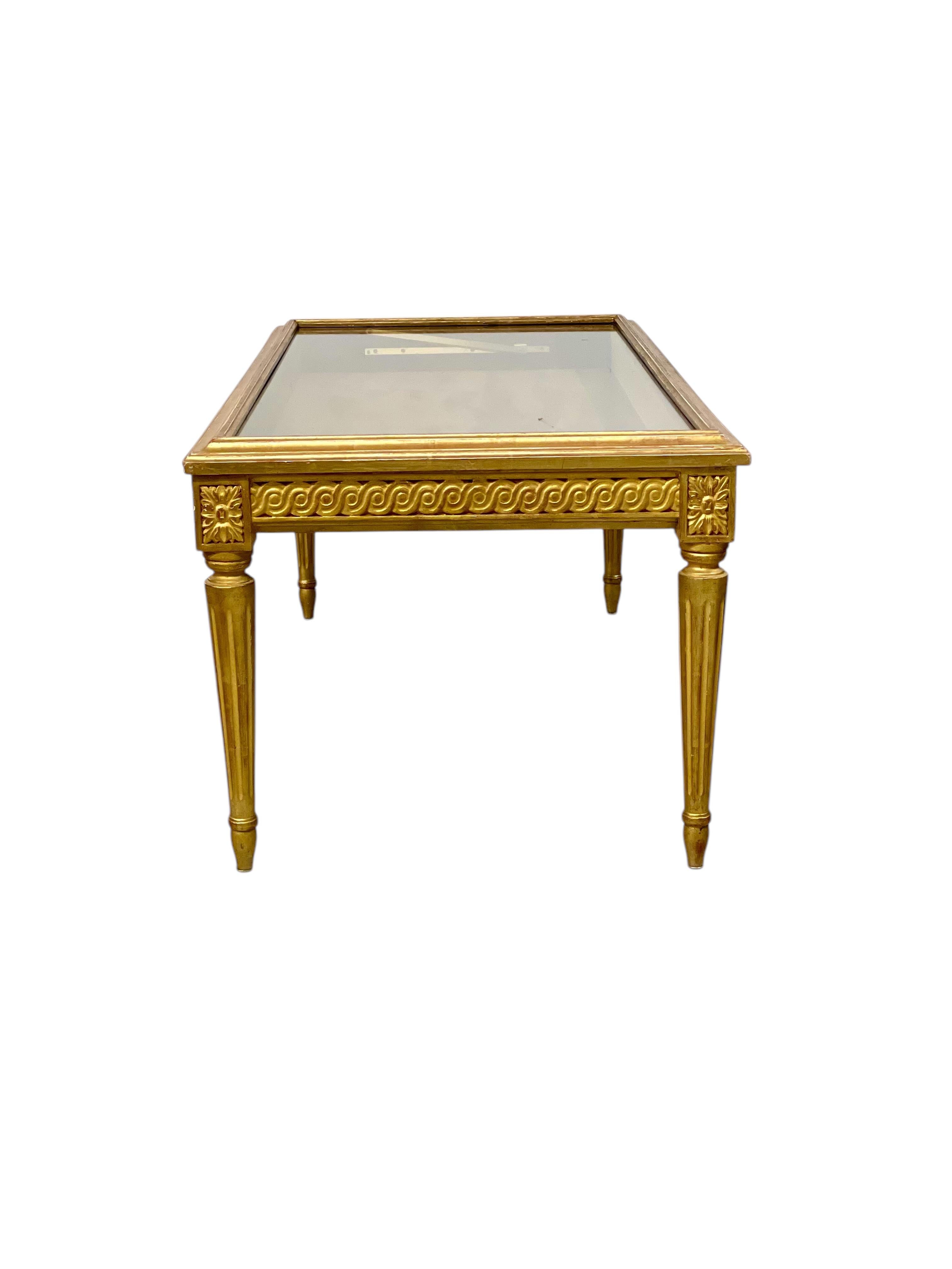 Dieser exquisite, im Louis-XVI-Stil gefertigte niedrige Tisch stammt aus dem späten 19. Jahrhundert und zeichnet sich durch außergewöhnliche Handwerkskunst und klassische Eleganz aus. Der wunderschön geschnitzte Holzrahmen ist mit vergoldeten