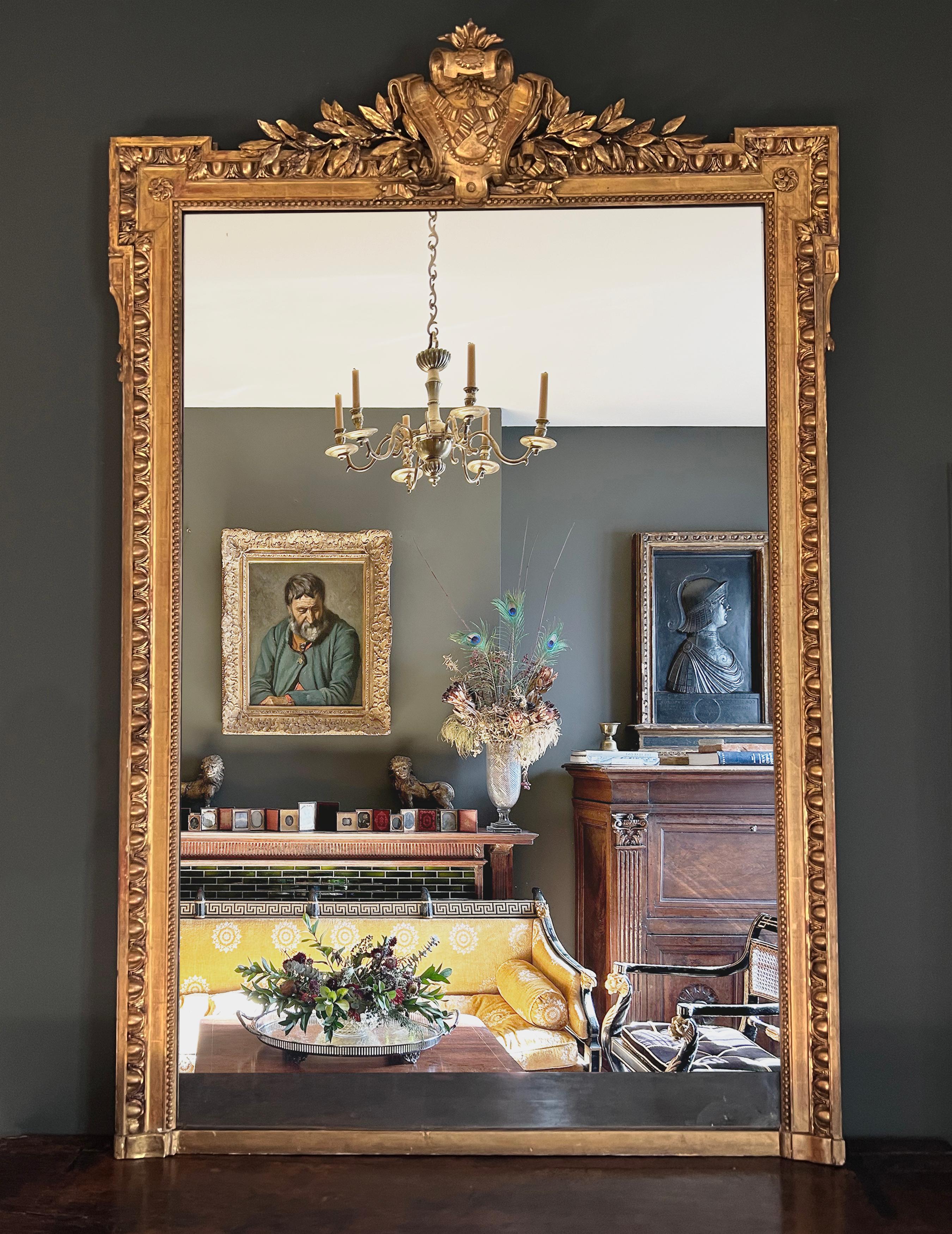 A magnificent and monumental neoclassical pier mirror from the Napoleon III era.  The original Mercury glass plate is bordered by an elegant egg and dart molding with the top of the mirror marked by eared Greek architraves and a laurel