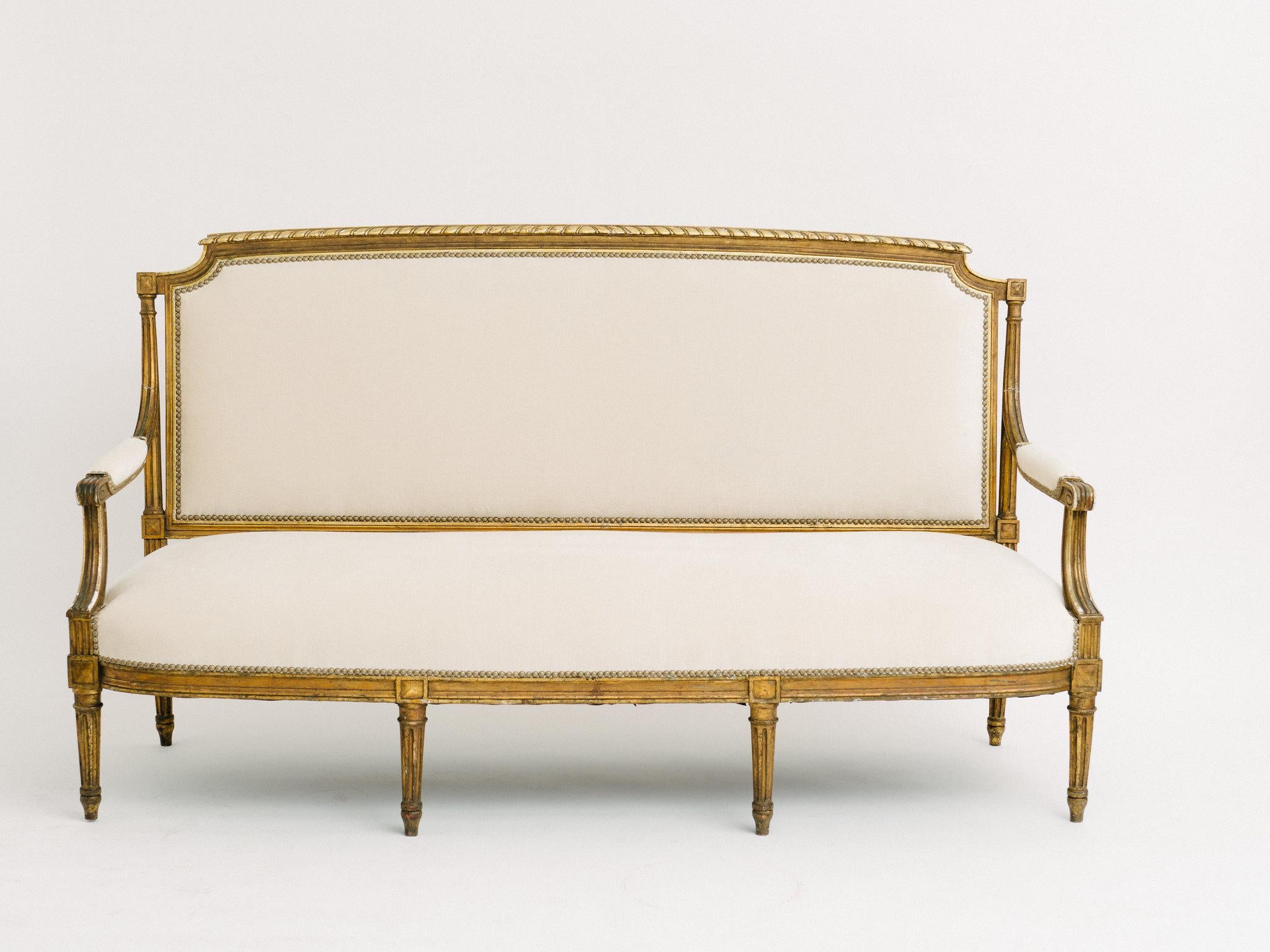 A lovely 19th century Louis XVI style settee newly upholstered in a creamy ecru mohair silk velvet with nailhead detail.
