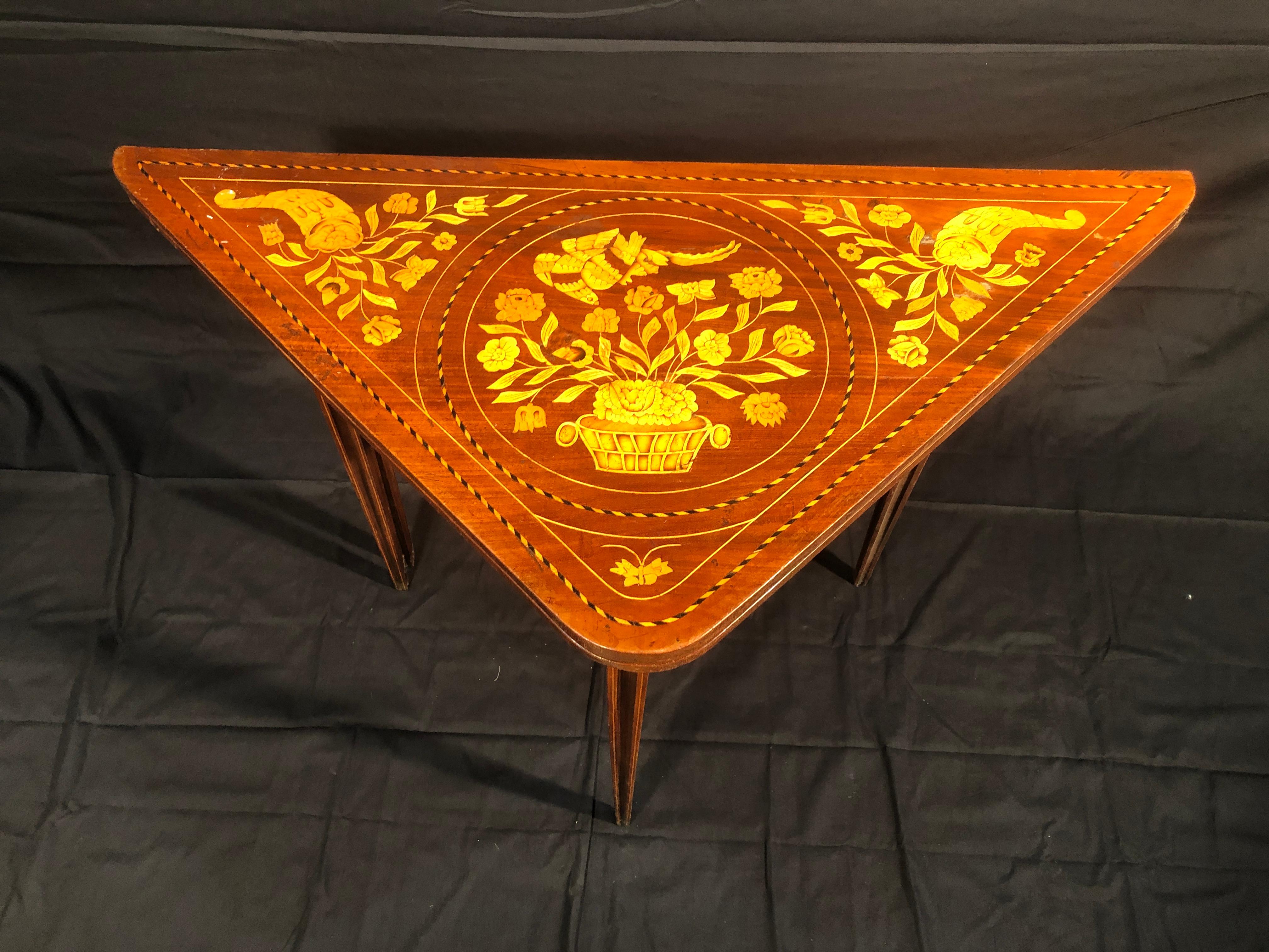 Dutch gaming table, circa 1840, triangle shape, possibility of doubling the floor, finely inlaid with floral motifs, in mahogany wood.
You can close it up to make it almost flat. To be restored.