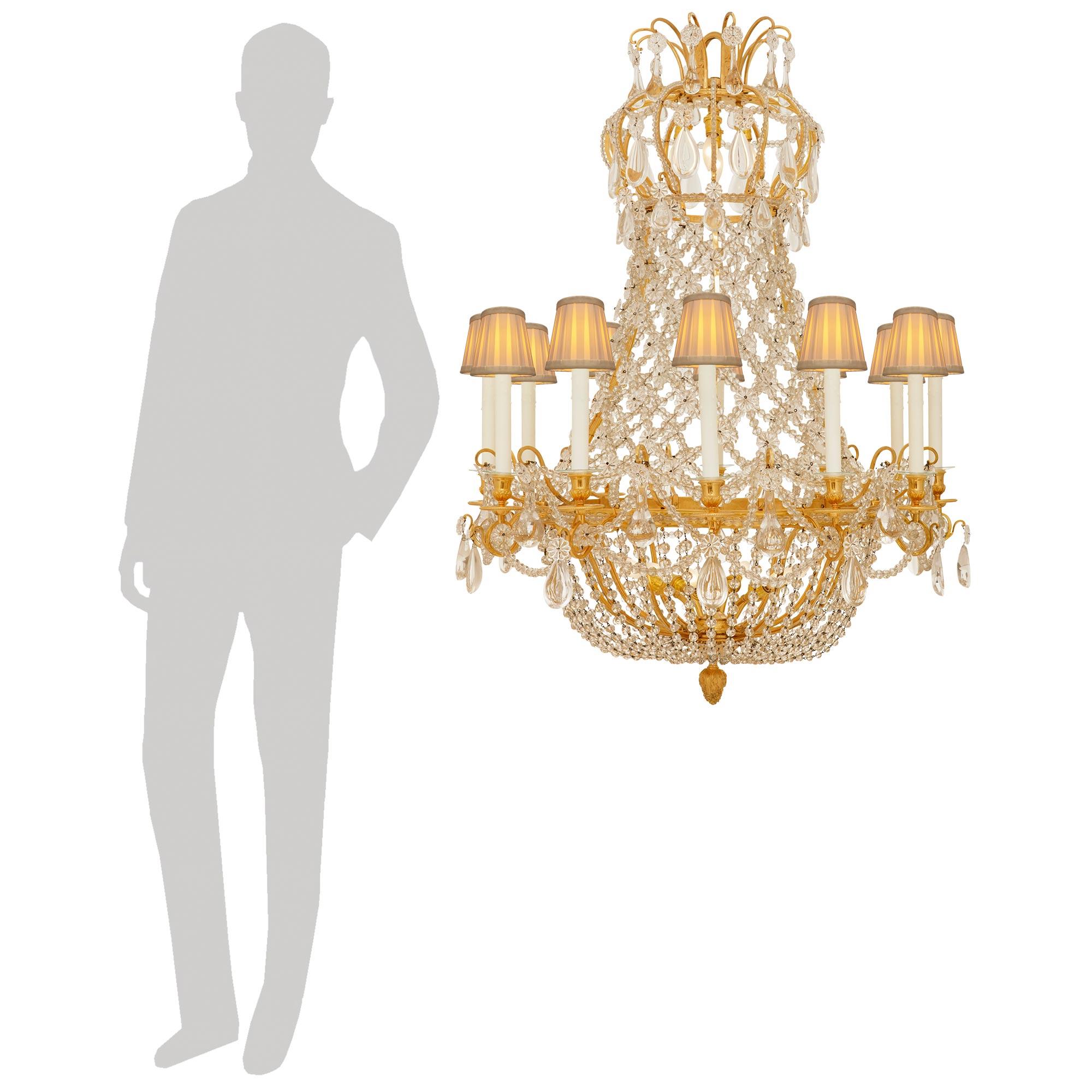 An elegant and high quality French 19th century Louis XVI st. Ormolu and Baccarat Crystal chandelier. This exquisite Montgolfière shaped twelve arm, nineteen light chandelier is centered at the bottom by a charming Ormolu foliate finial below a