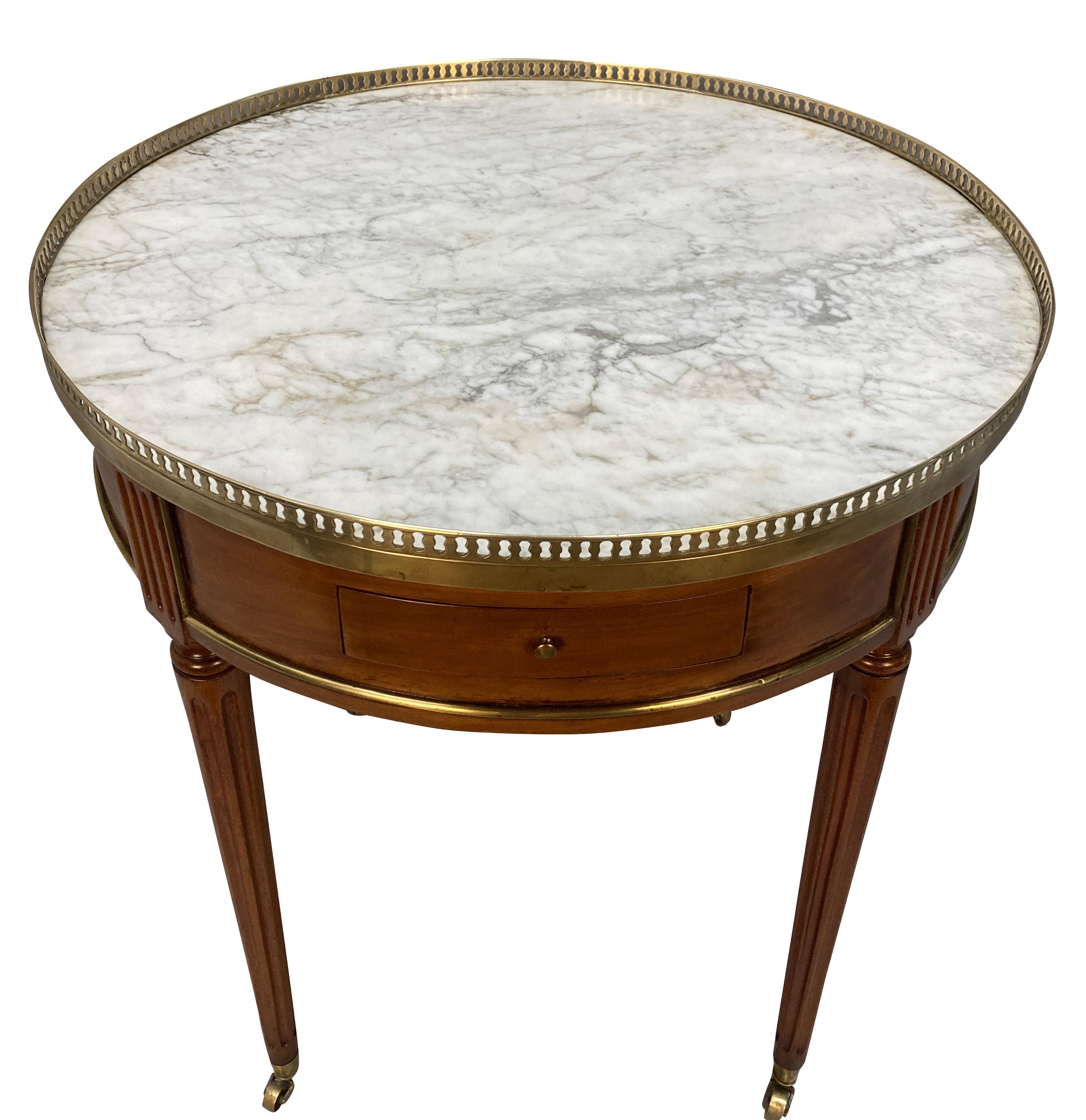 A French, late XIX Century bouillotte table in the Louis XVI manner, in mahogany, with brass detailing. With leather clad slides and drawers and a pierced gallery.