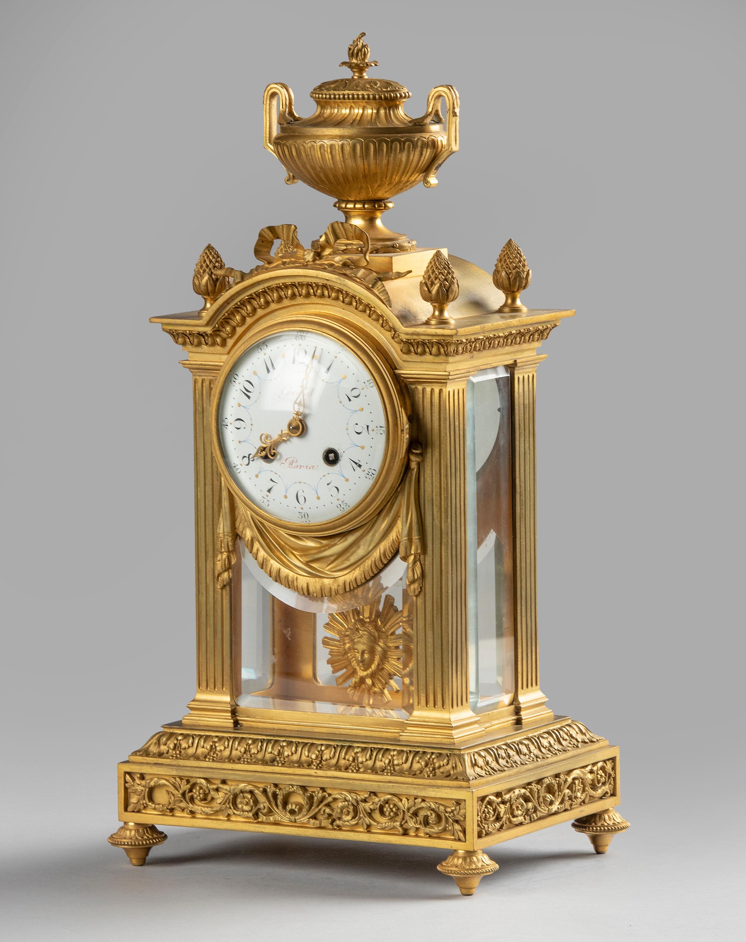 A fine Louis XVI style French mantel clock from the Napoleon III period. The clock is bronze casted and has a fire-gilded finish, the dial is enameled iron. Richly all around embellished with neoclassical ornaments such as a lidded urn at the top,