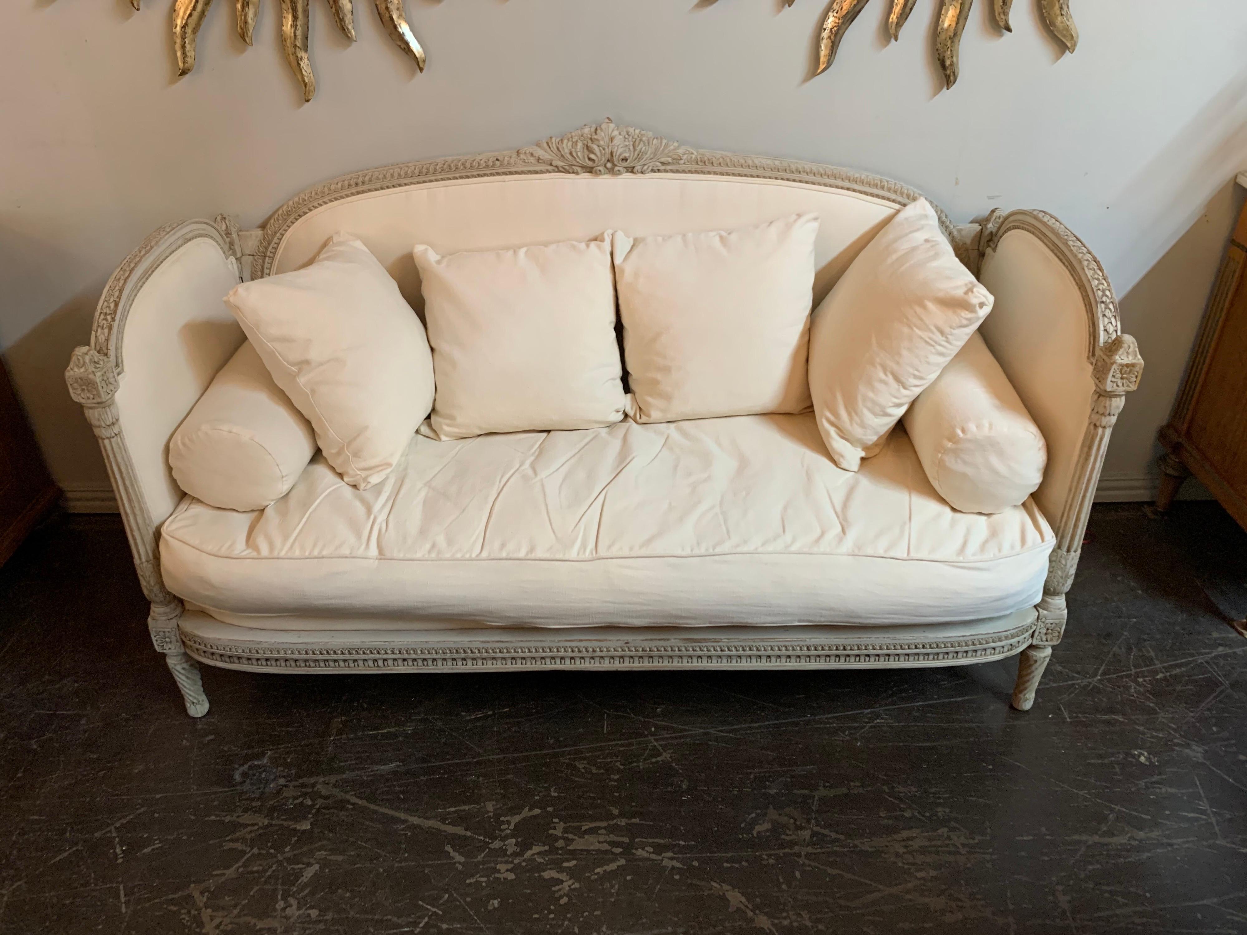 Lovely 19th century Louis XVI style carved and painted sofa. Upholstered in a beautiful creme colored linen. Exceptional carvings and so stylish. Comfortable as well! Better hurry! This will not last long.