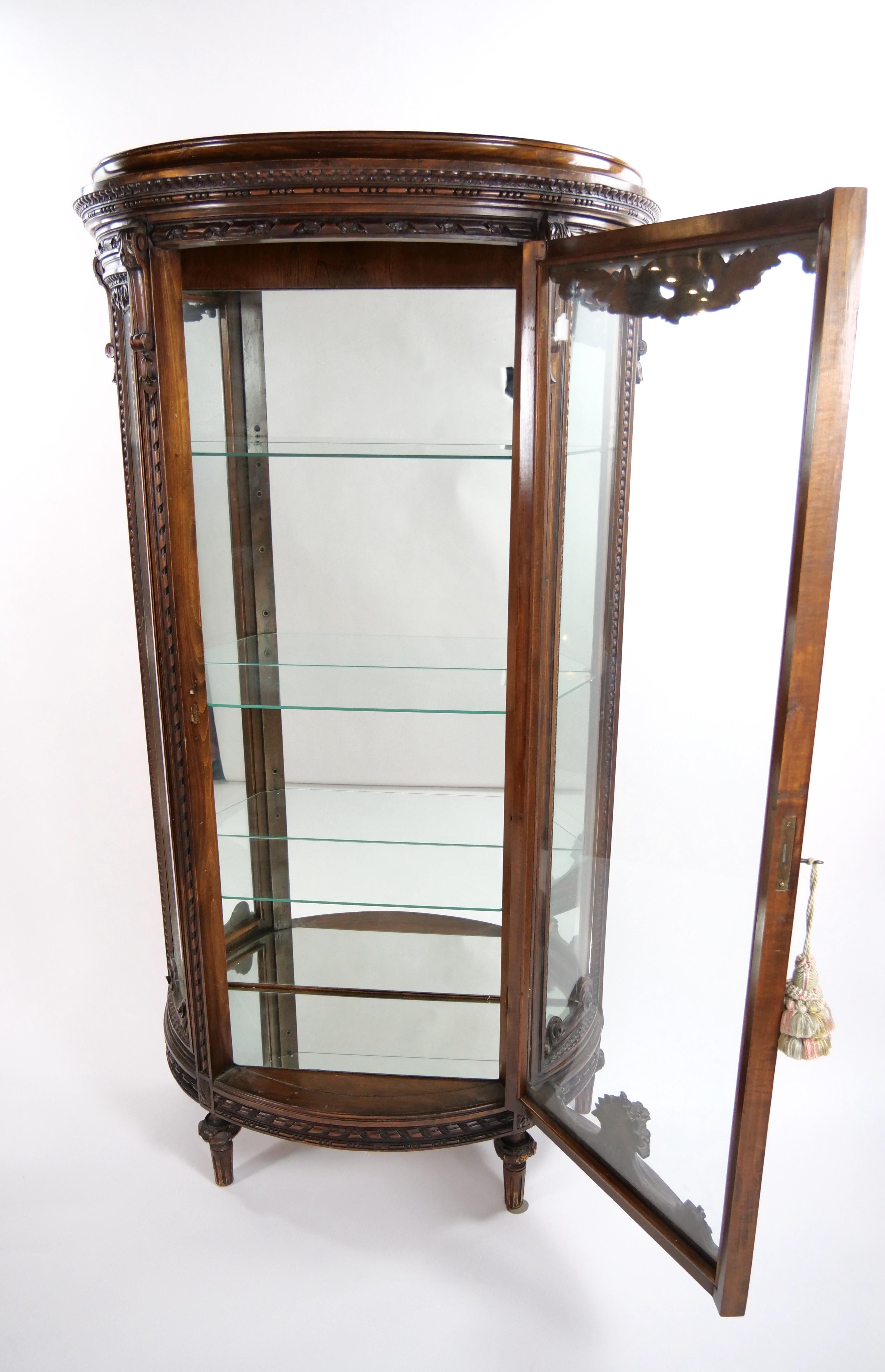 Questa splendida vetrinetta in stile Luigi XVI del XIX secolo incarna eleganza e raffinatezza. Caratterizzato da un'inconfondibile forma demi-lune, il mobile vanta un lussuoso piano in marmo che corona la sua struttura in legno intagliato a mano.