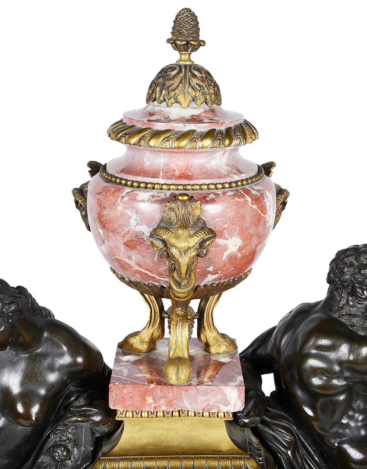 A very impressive 19th century French gilded ormolu, rouge marble and bronze mantel clock. Having two classical reclining bronze nude male figures, either side of a rouge marble urn and the eight day duration, chiming clock. Seated on a gilded