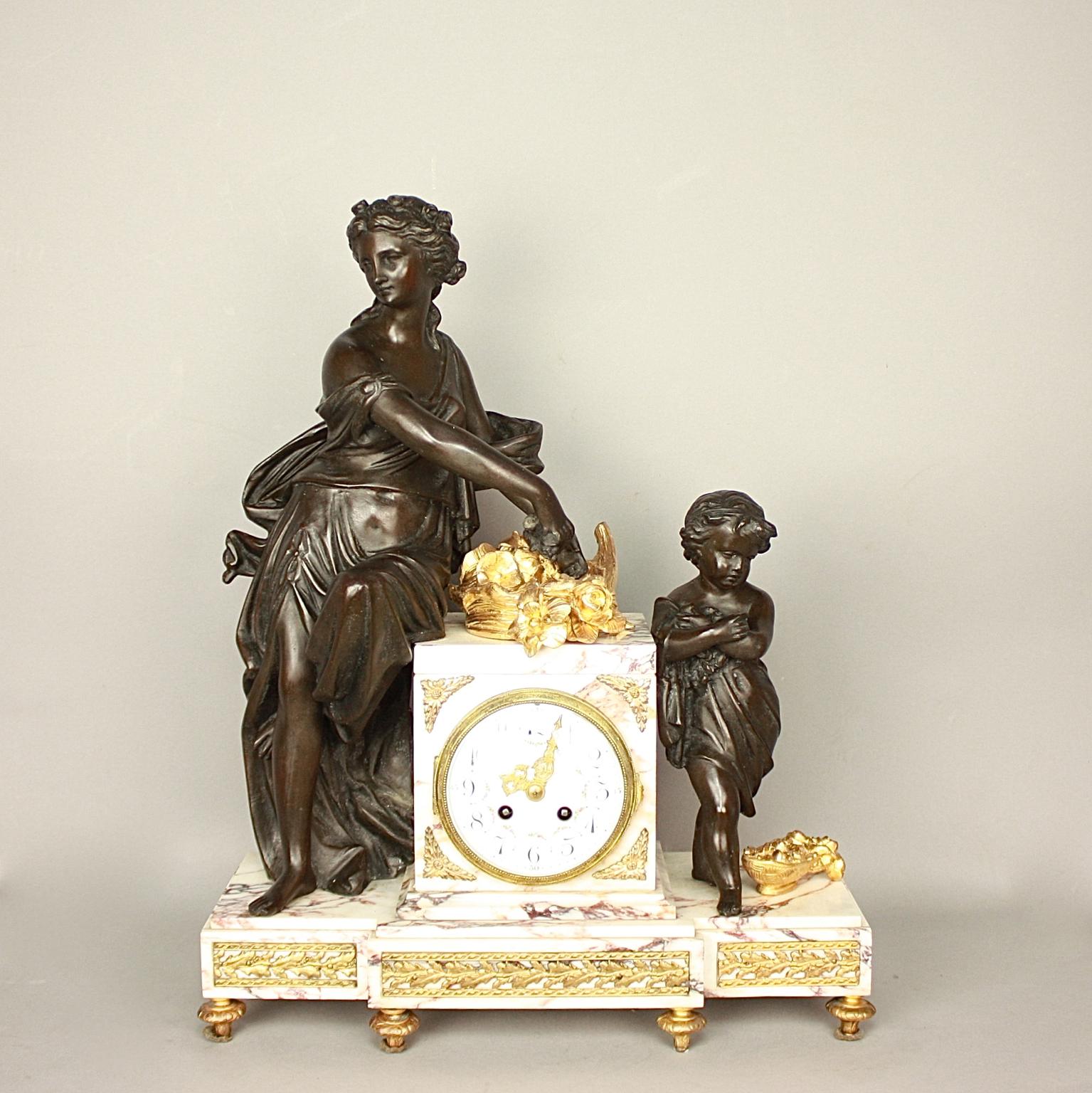 A 19th century Louis XVI style clock garniture, a so called 'Garniture de Chemineé'. The mantle clock with two matching vases constructed of pink veined marble and gilt metal. The rectangular drum case with a finely painted enamel dial, Arabic