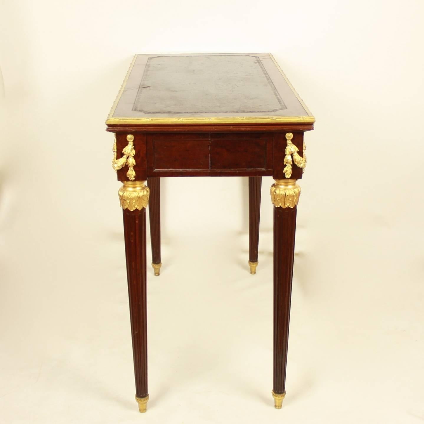 A 19th century Louis XVI style extending game table made of acajou mouchete mahogany and adorned with high quality ormolu mounts. The game table hosts an interesting mechanism: the back legs can be pulled out by pressing a hidden wooden button