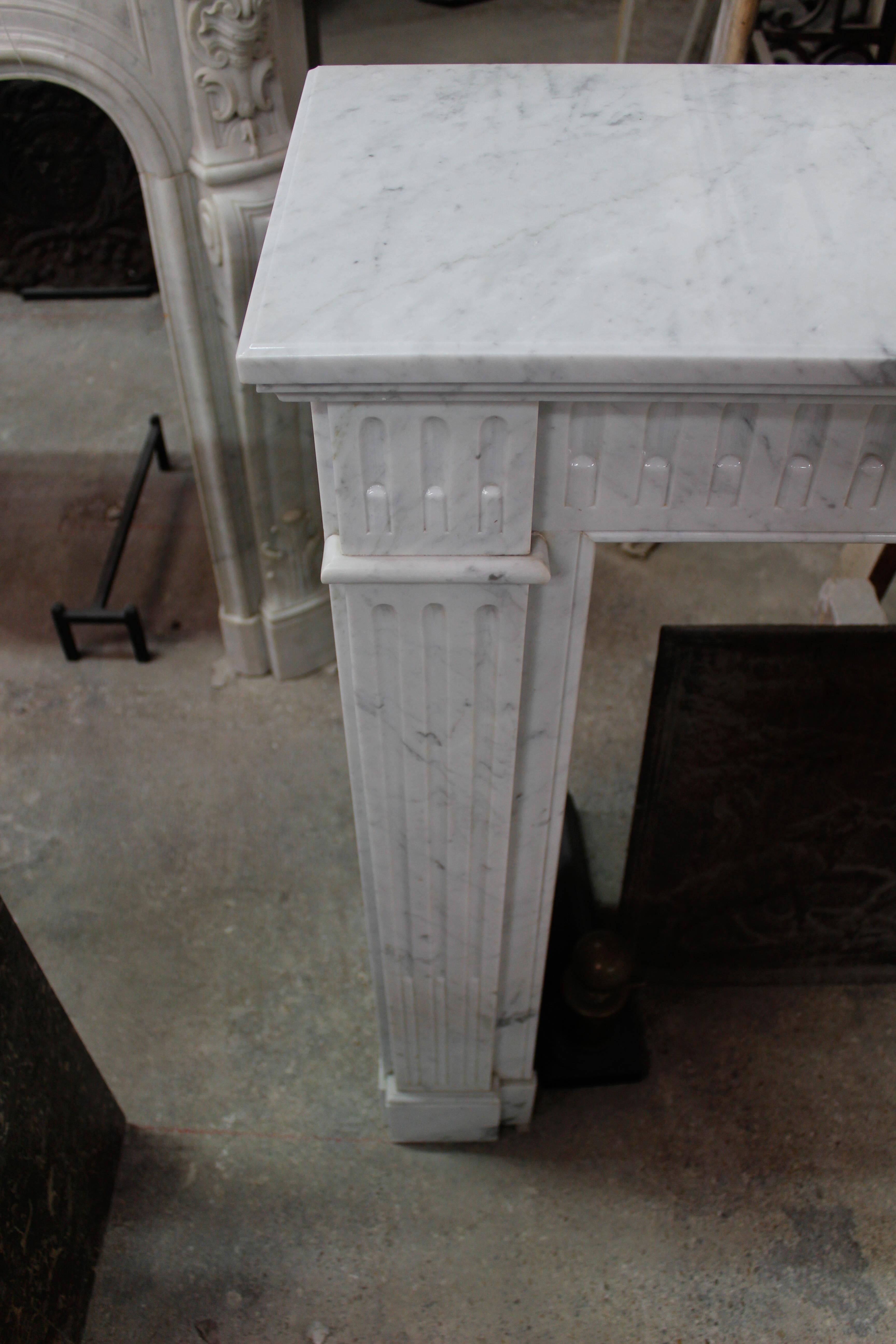 Carved 19th Century Louis XVI Style Fireplace in White Carrara Marble For Sale