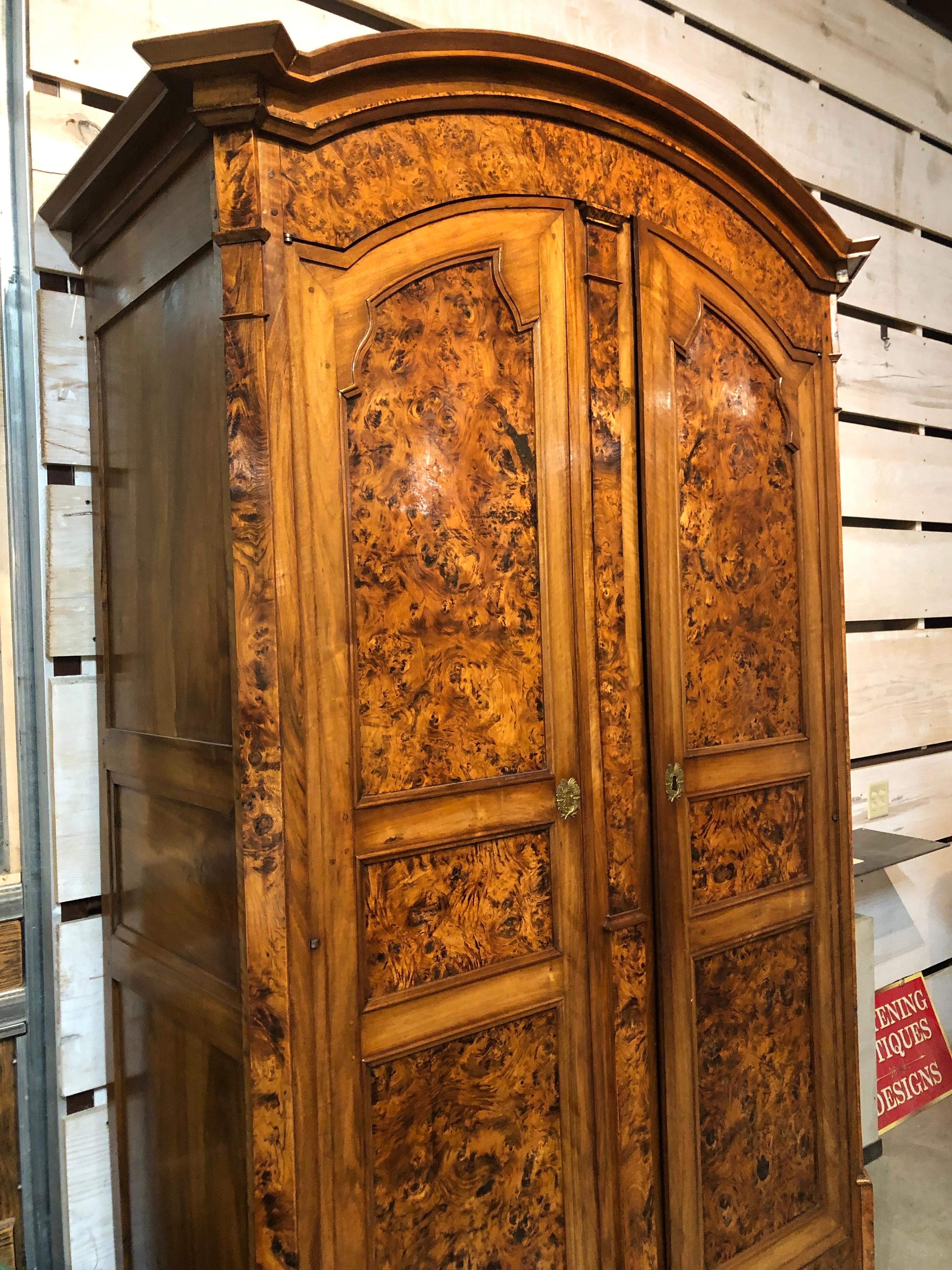 Extraordinary Louis XVI style French provincial armoire made of beautiful burled ash, deep rich patination with remarkably figured ash and walnut. Two large doors open to reveal interior wood details and plenty of storage space. Excellent condition,