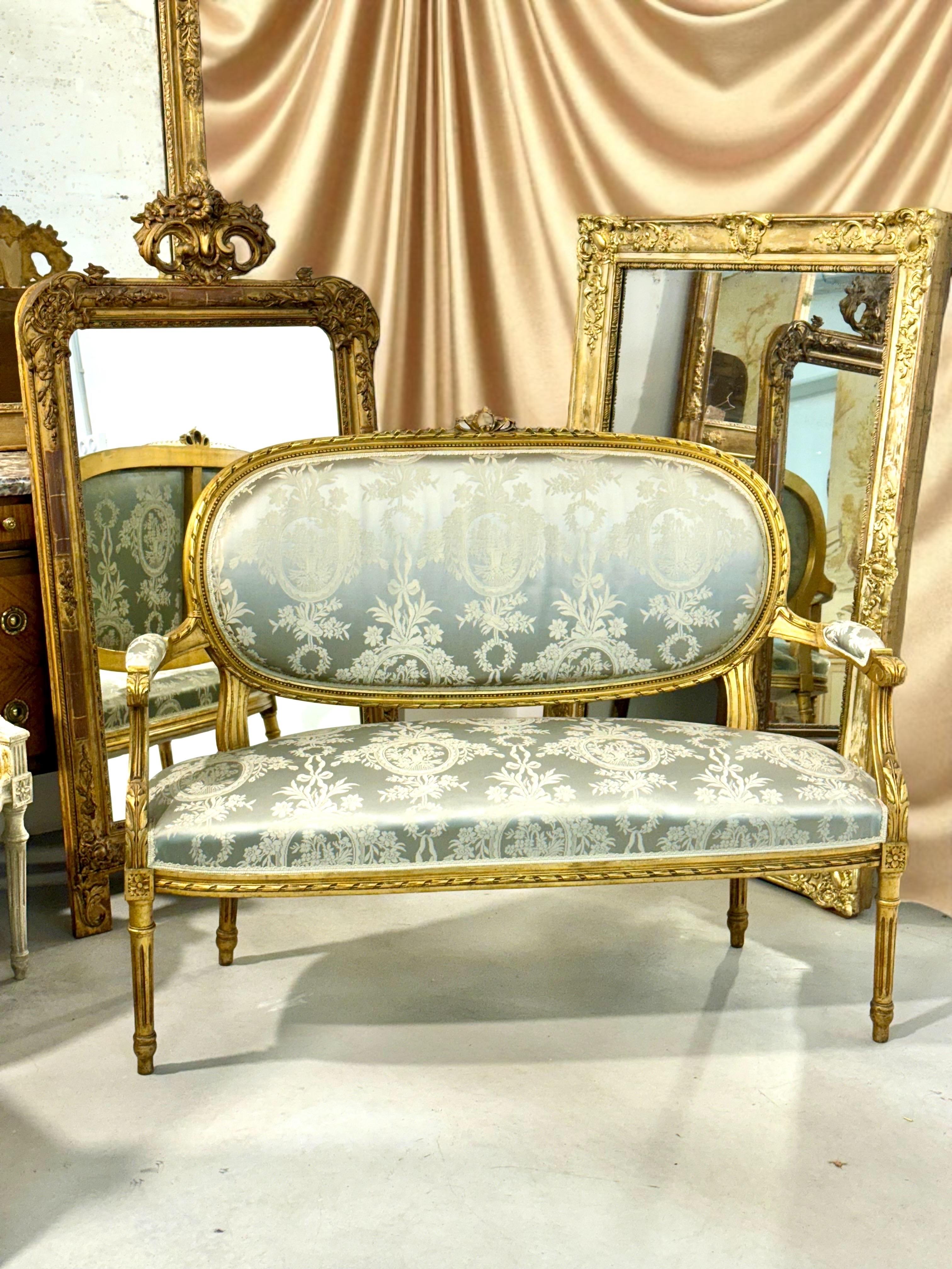 Dieses exquisite französische Sofa aus dem 19. Jahrhundert verkörpert mit seinen perfekt ausgewogenen Proportionen, den raffinierten Schnitzereien und der leuchtenden Vergoldung die zeitlose Eleganz des von Ludwig XVI. inspirierten Designs.