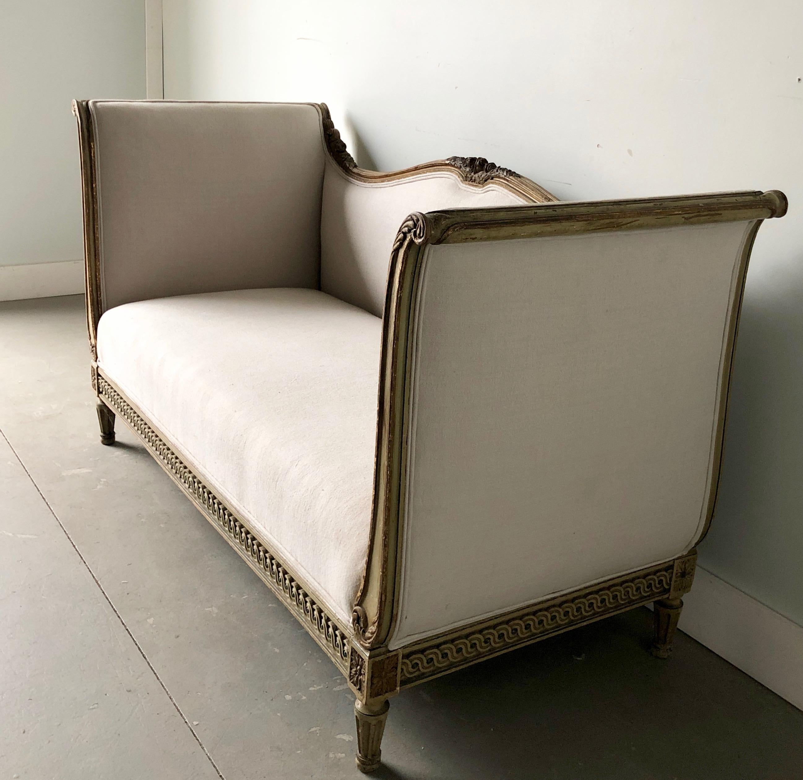 19th century Louis XVI style exceptional carved and painted sofa with conical fluted legs. Upholstered in a beautifully in cream/off-white linen.
  