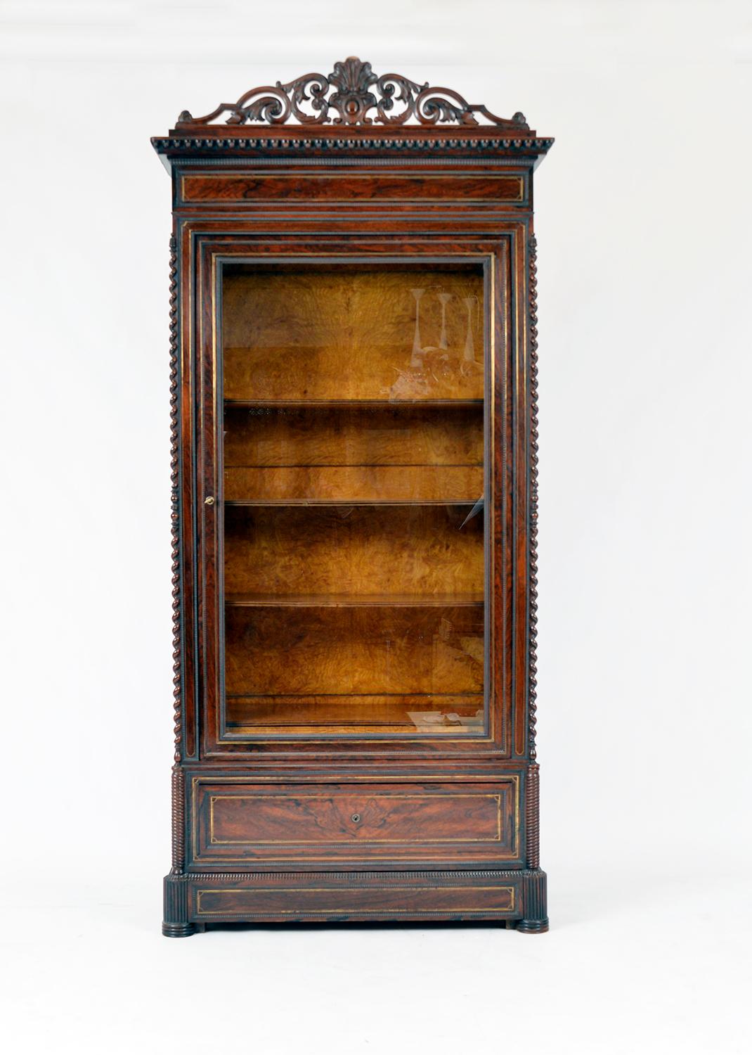 A magnificent example of 19th century French Decorative Arts. The vitrine is pure opulence and has had no expense spared, with exotic decoration and materials used from top to bottom. 
The exterior is figured rosewood with delicate brass inlay,