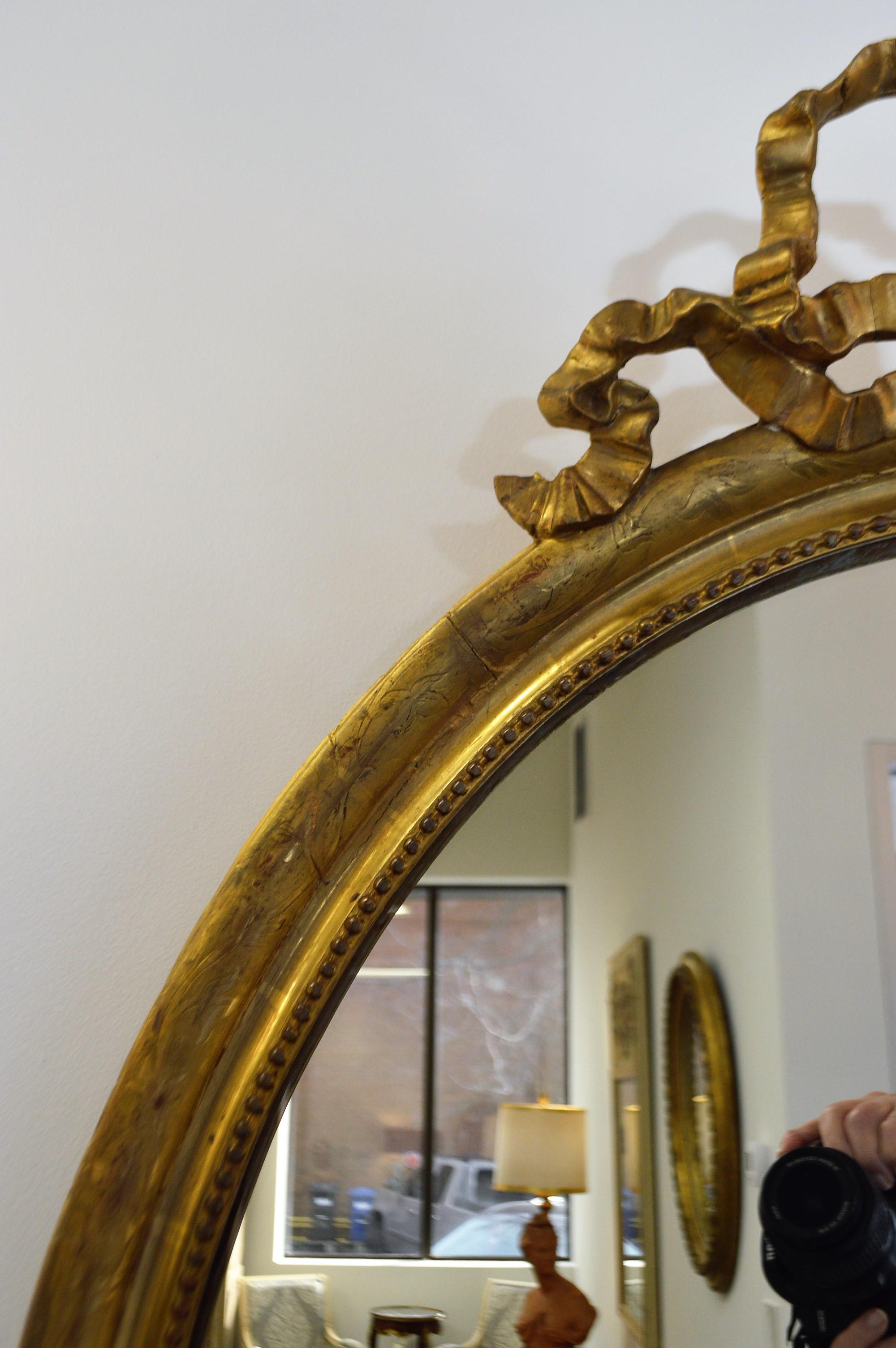 French 19th Century Louis XVI Style Gilded Oval Mirror, a Large Bow above the Frame