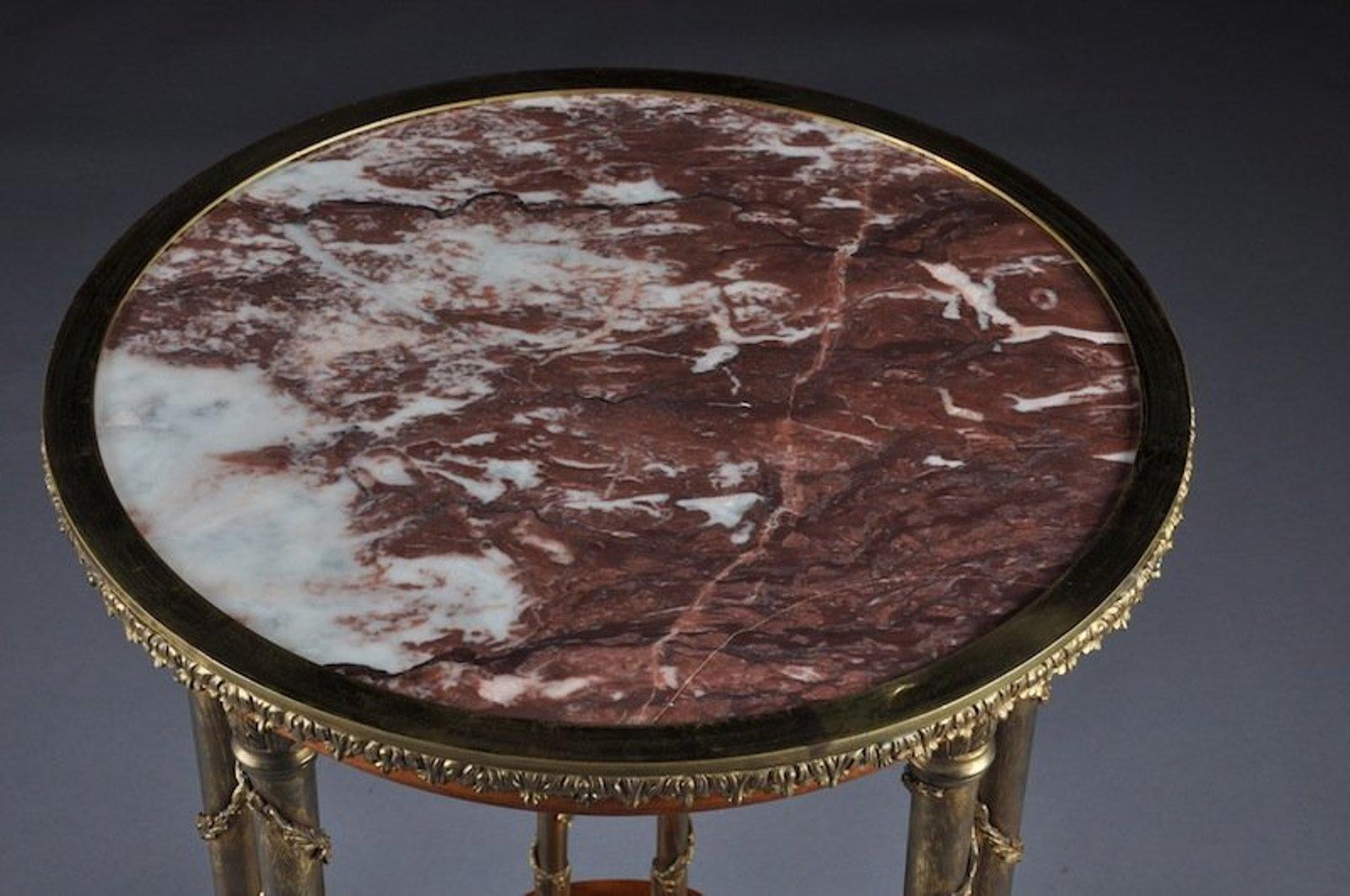 The Following Items we are Offering is A GILT BRONZE MOUNTED BURL WOOD ADAM WEISWEILLER GUÉRIDON TABLE.  the circular rouge marble top within a conforming flat band above leaf-tip cast trim and tapering molded frieze, raised on vine entwined paired