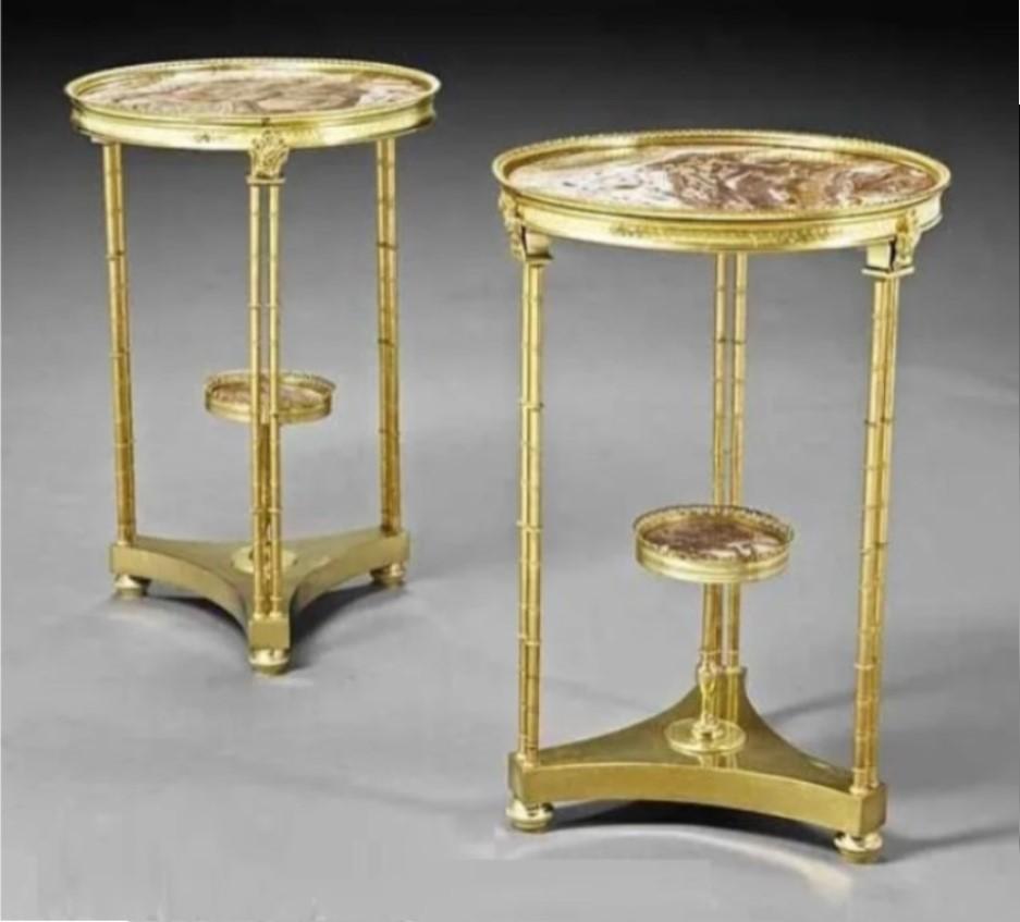 L'article suivant est une paire de tables de guéridon en bronze doré de style Louis XVI, montées sur bronze, à la manière d'Adams Weisweiler.  Chacune repose sur trois paires de colonnes en faux bambou bronzé, chaque pied étant orné d'une guirlande.