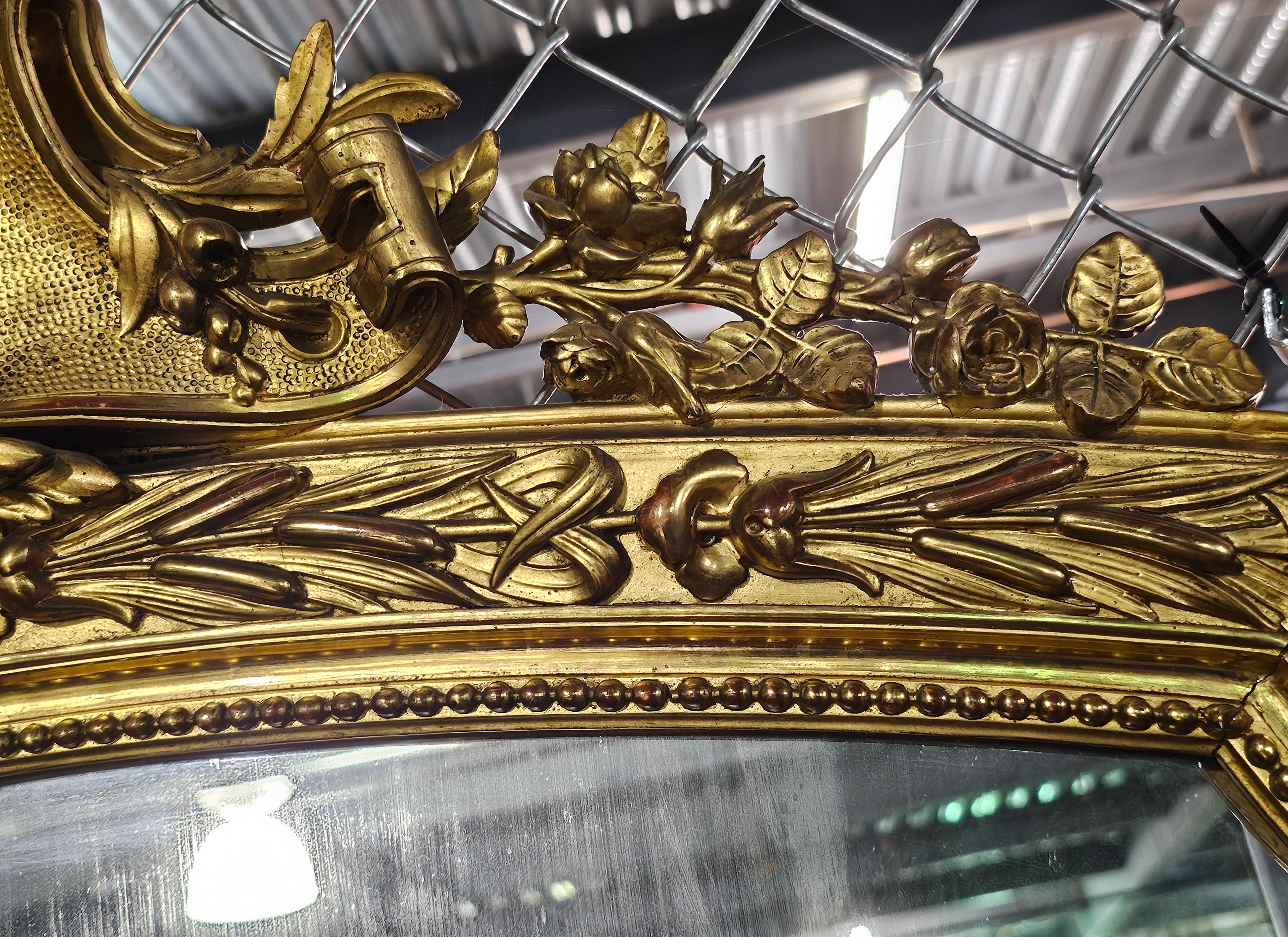 Magnifique grand miroir mural en bois doré décoré de feuillages, de style Louis XVI, datant du 19e siècle. Mesure 48