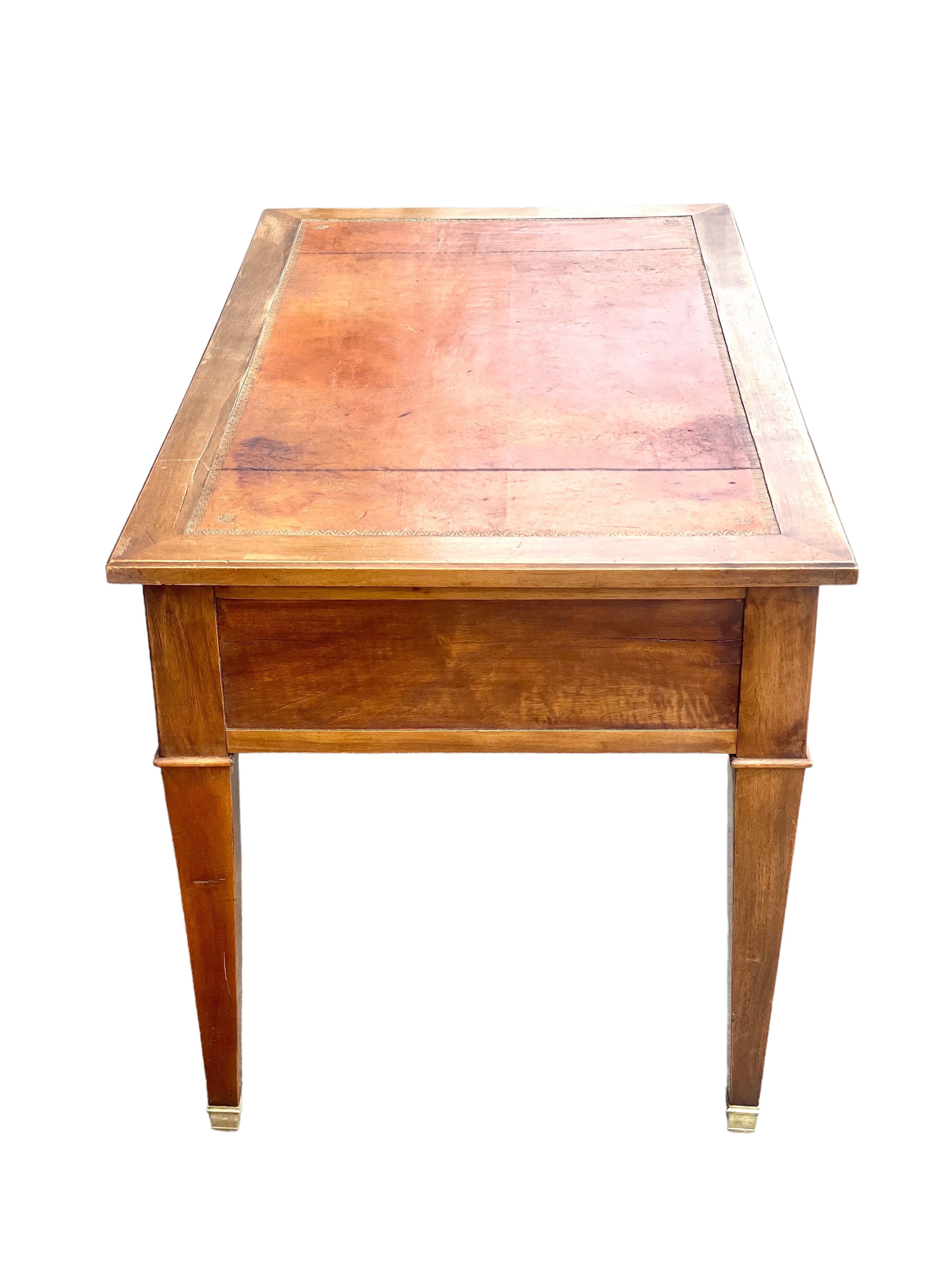 A lovely 19th century French leather-topped writing desk in warm-coloured walnut and veneer. Hand-crafted in the Louis XVI style, this charming desk has two lockable drawers complete with shield-shaped escutcheons (one key supplied). The rectangular