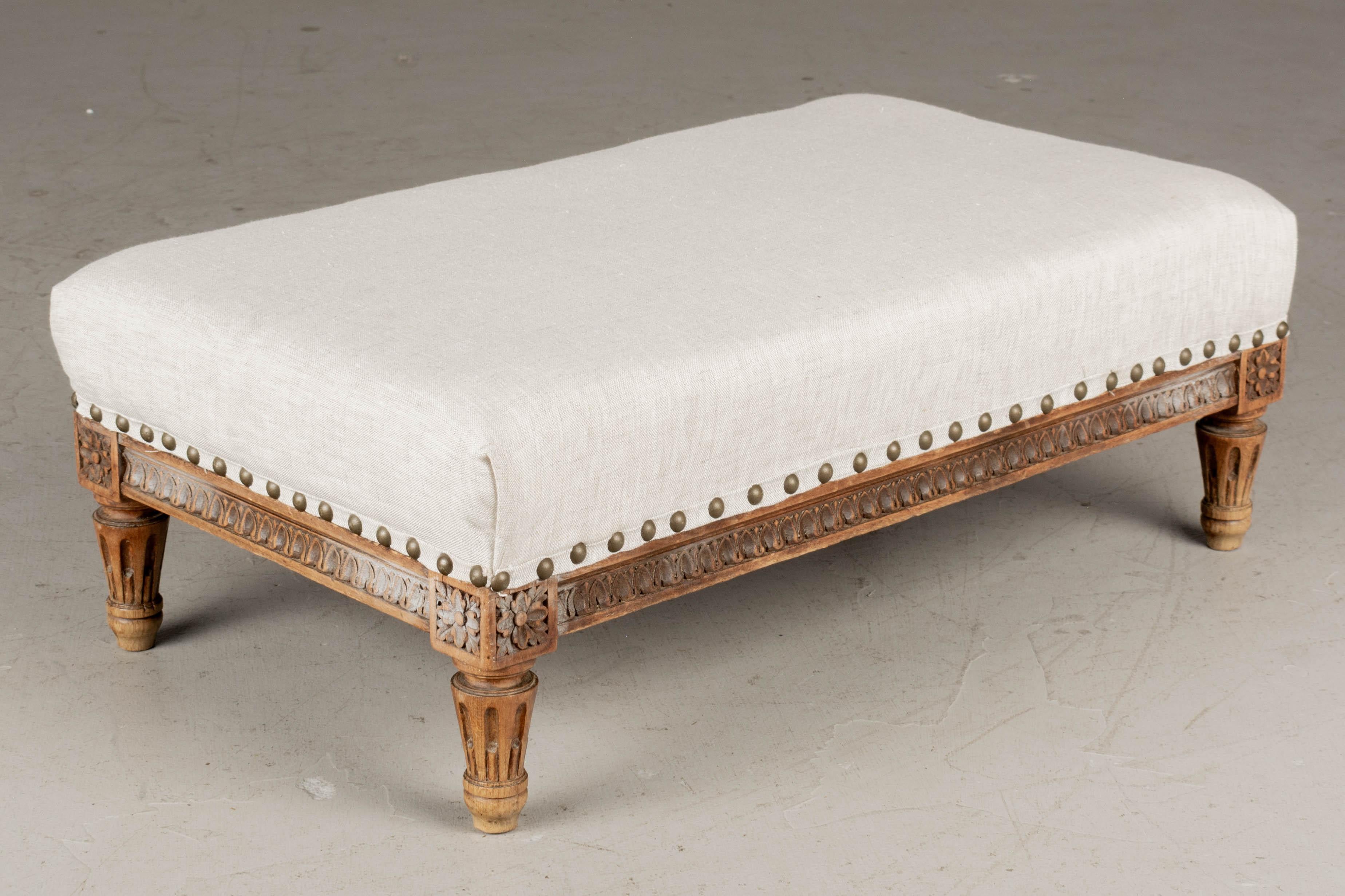 A 19th century Louis XVI style low footstool or ottoman, made of beech wood with hand-carved frame and short turned tapered peg legs. Newly upholstered with brass nail head trim.
Contact us for a competitive shipping quotation. Please refer to