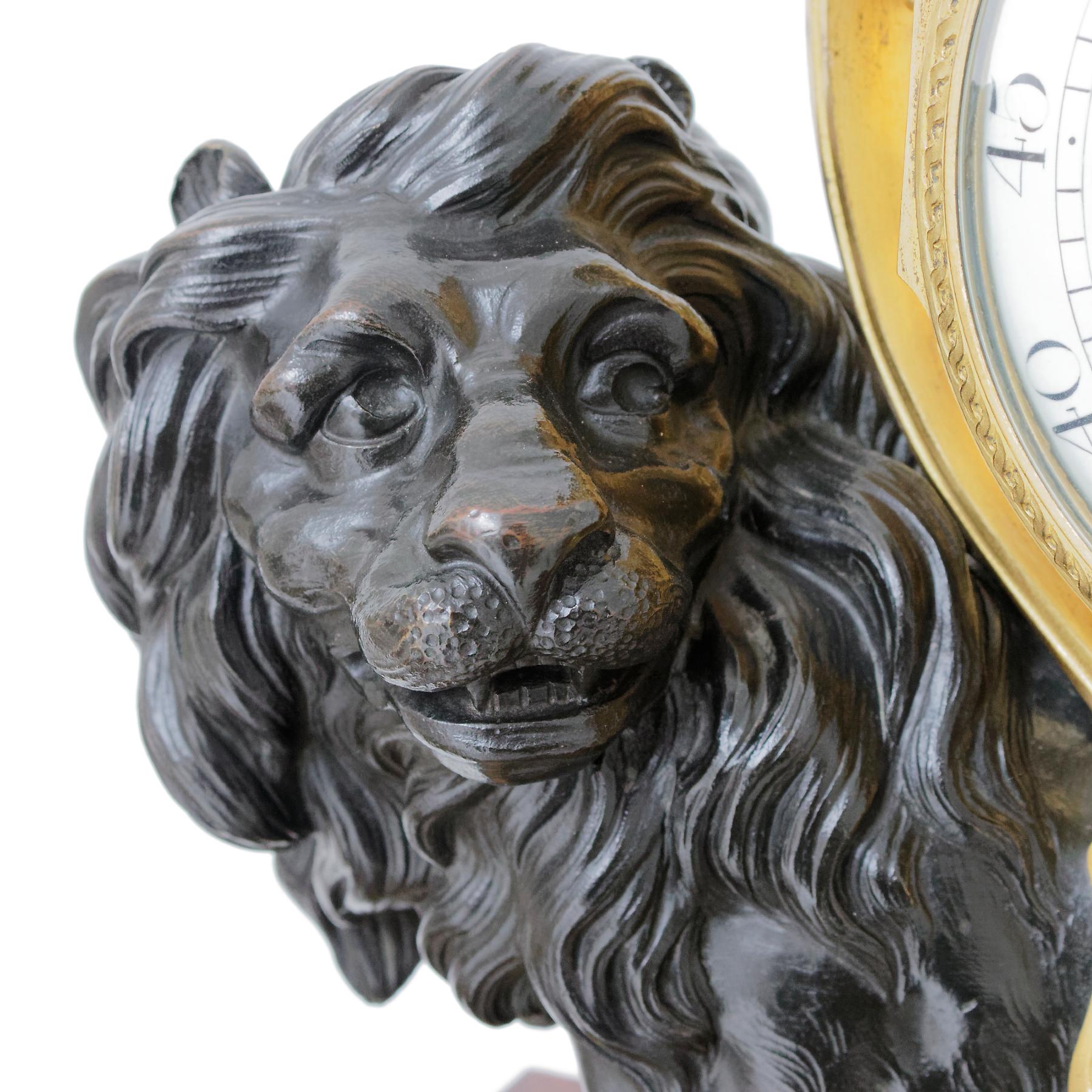 L'horloge est signée par l'Horloger Festeau Le Jeune. Le boîtier d'après un dessin de François Vion en forme de lion supportant une boîte cylindrique drapée de guirlandes de laurier nouées de rubans et surmontée d'une urne couverte suspendue à une