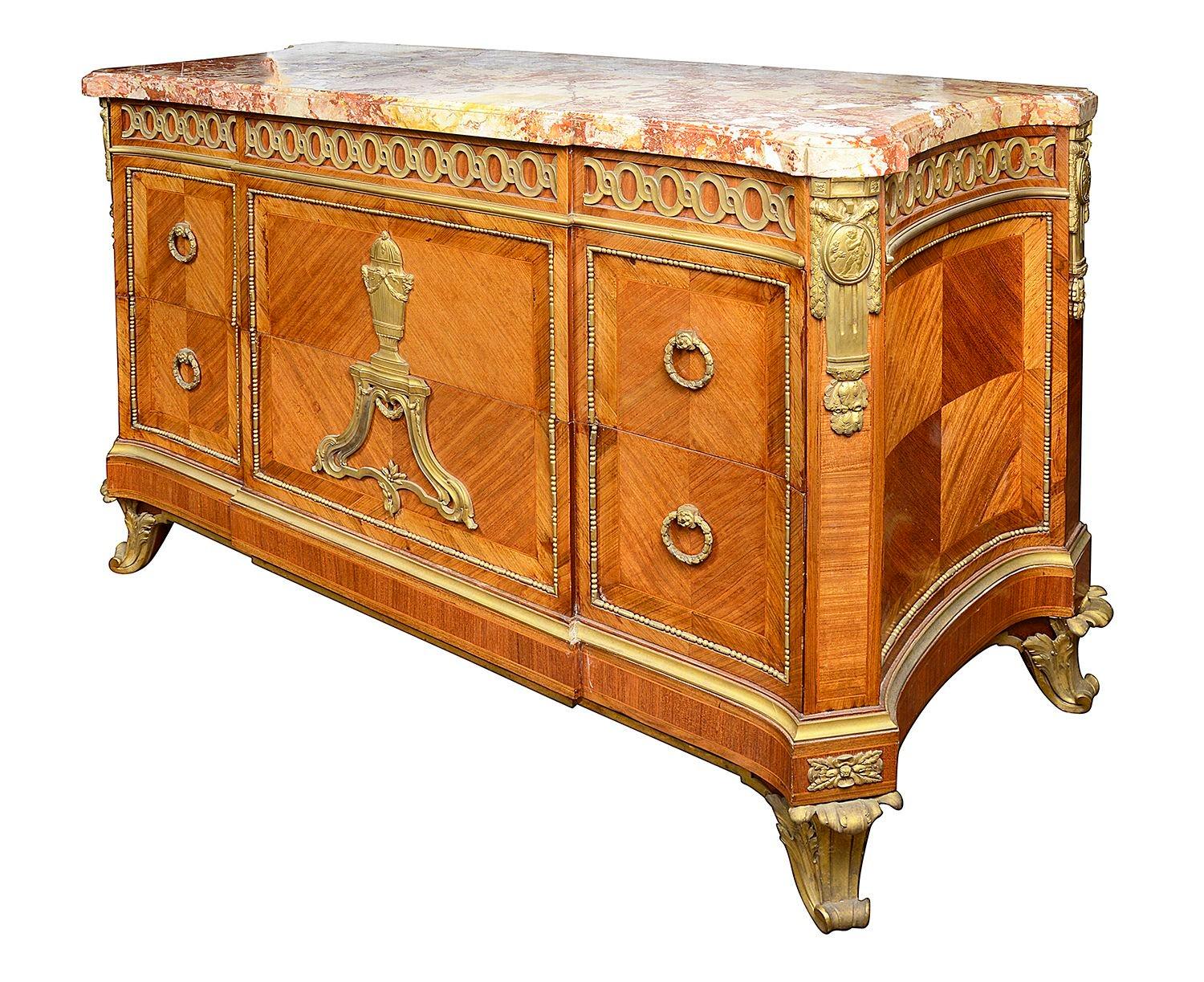 A very impressive French Louis XVI style, 19th Century Marble topped commode, having wonderful gilded ormolu mounts and mouldings, quartered veneers to the drawer fronts and sides. Having the original Breccia marble top, an ormolu classical urn on