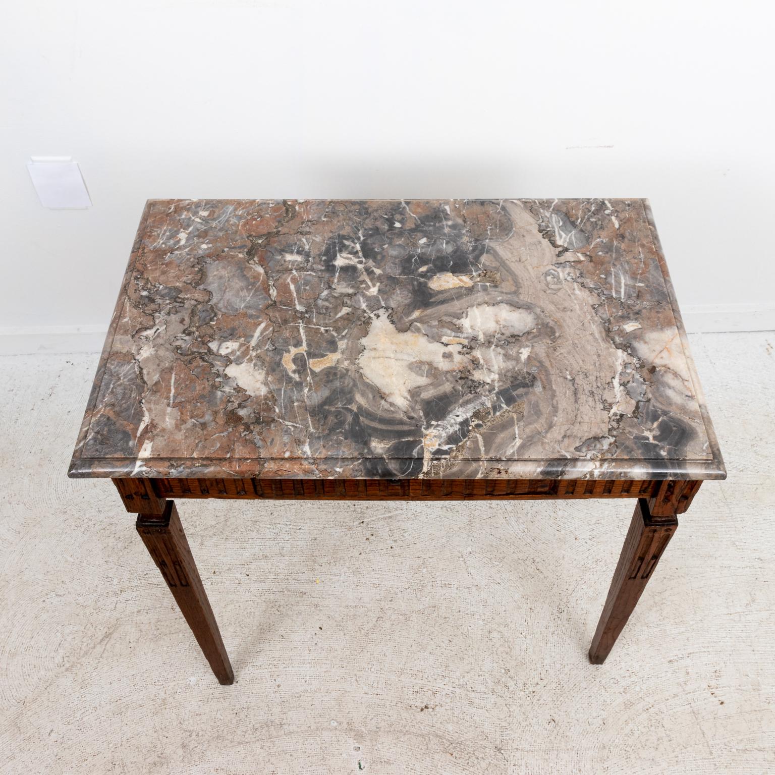 Circa 19th century Louis XVI style oak and marble top side table with tapered legs and single hidden drawer. Please note of wear consistent with age including minor finish loss to the wood.