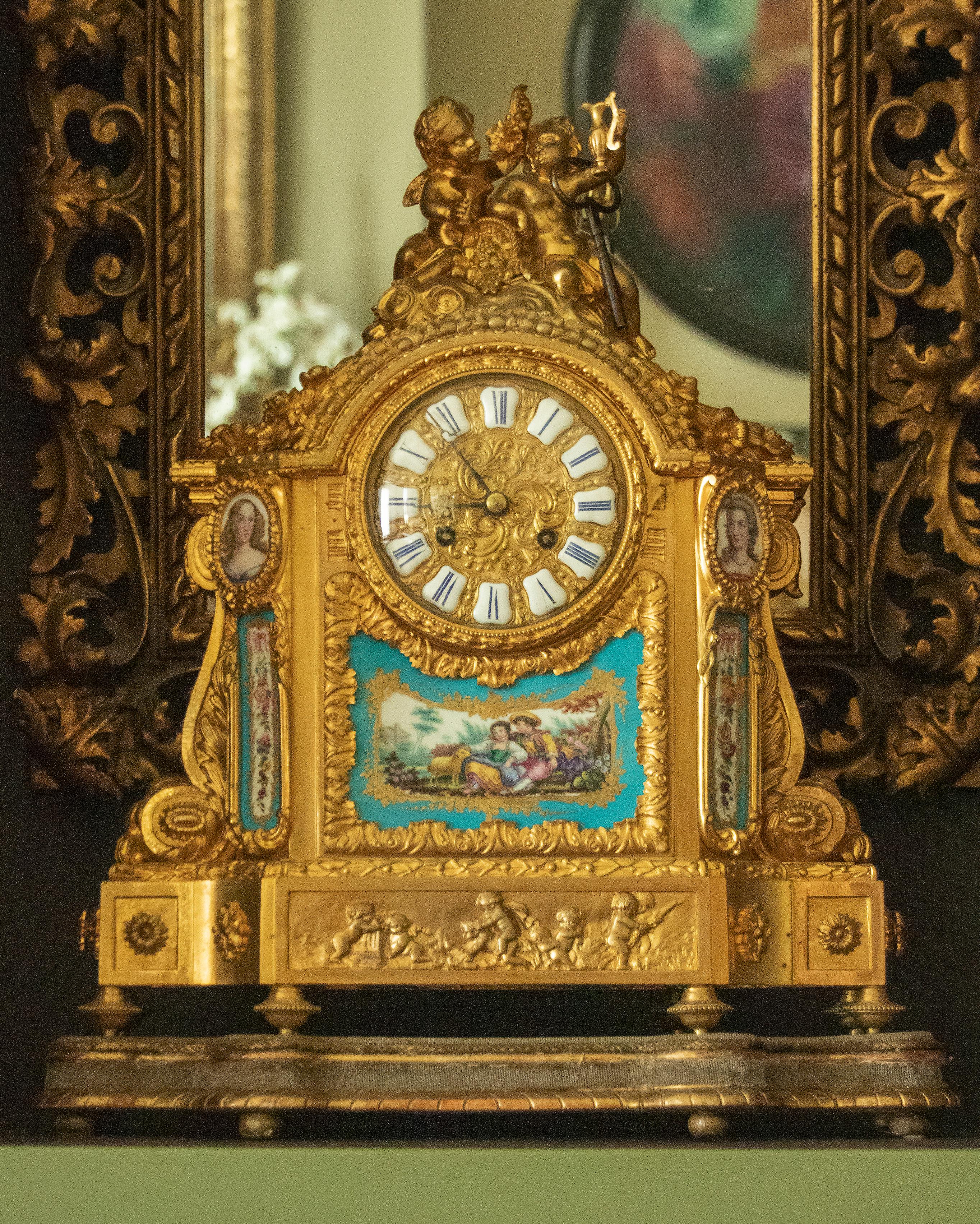 A fine quality Louis XVI style bronze ormolu mantel clock. The case is made of gilt brass and bronze ormolu casted ornaments, Roman numerals in white enameled cartouches. On top of two wine drinking putti with a basket of grapes and wine.