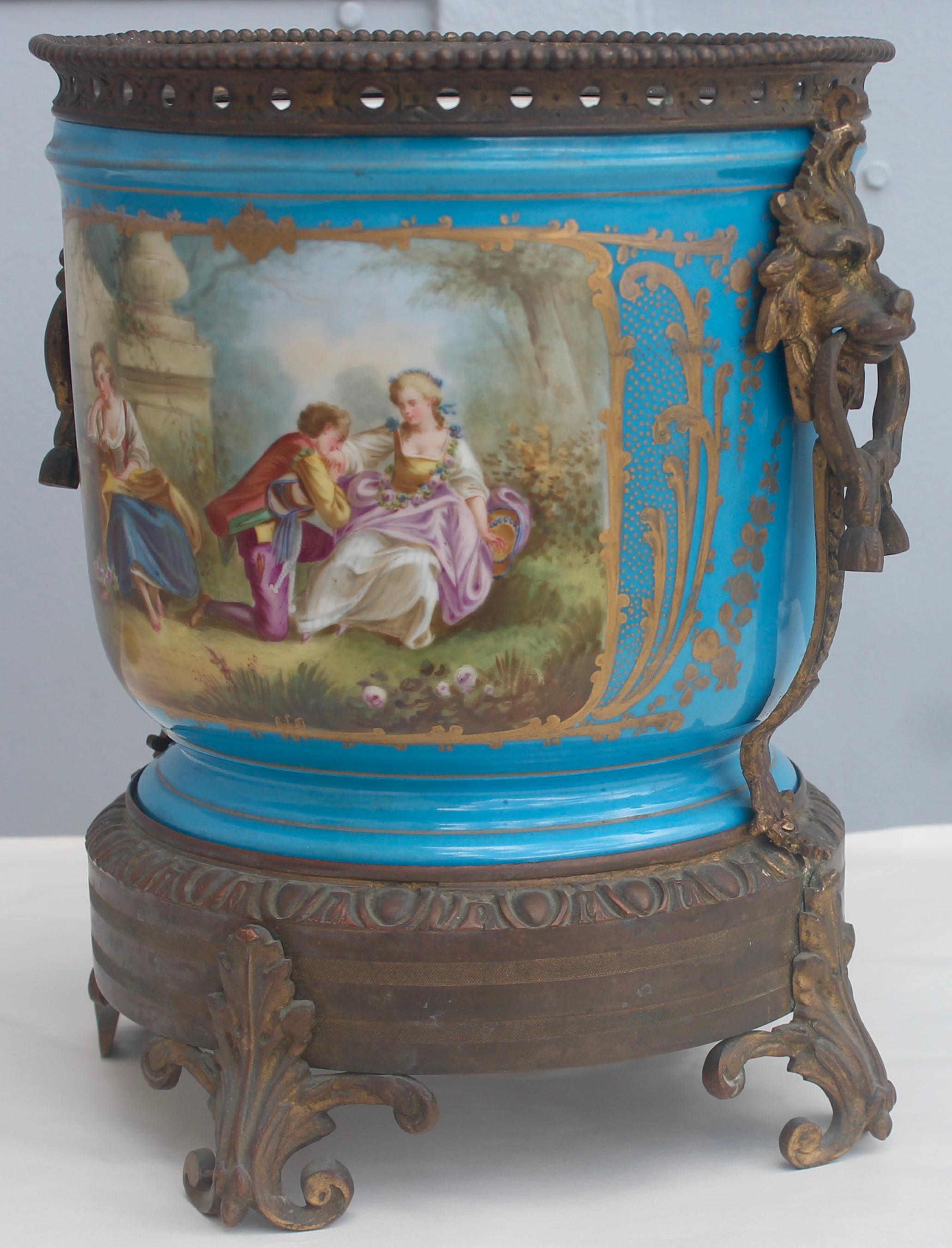 Antique Sèvres blue Céleste Porcelain cachepot
Romantics scenes hand painted on the front reserves and flowers on the verso.
Ormolu-mounted with a gilt bronze base and a gadrooned edge on the rims.
Gilt bronze lions masks with rings in their