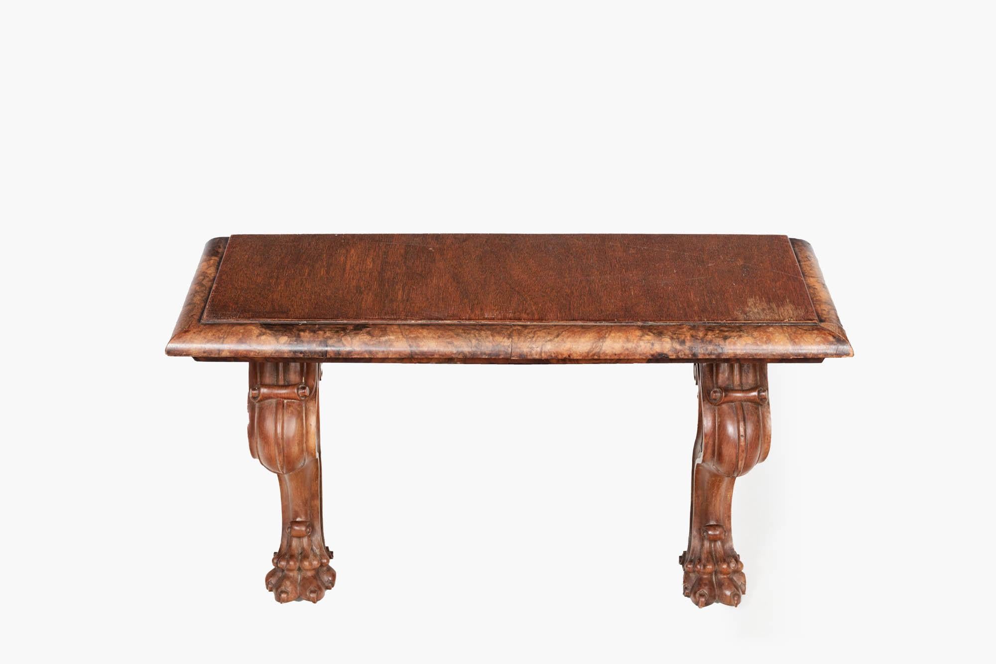 19th century low console table with crossbanded top and a carved walnut edge. The double pedestal cabriole legs terminate in carved hairy paw feet.

Console tables were first introduced in France in the 17th century as a rectangular slab supported