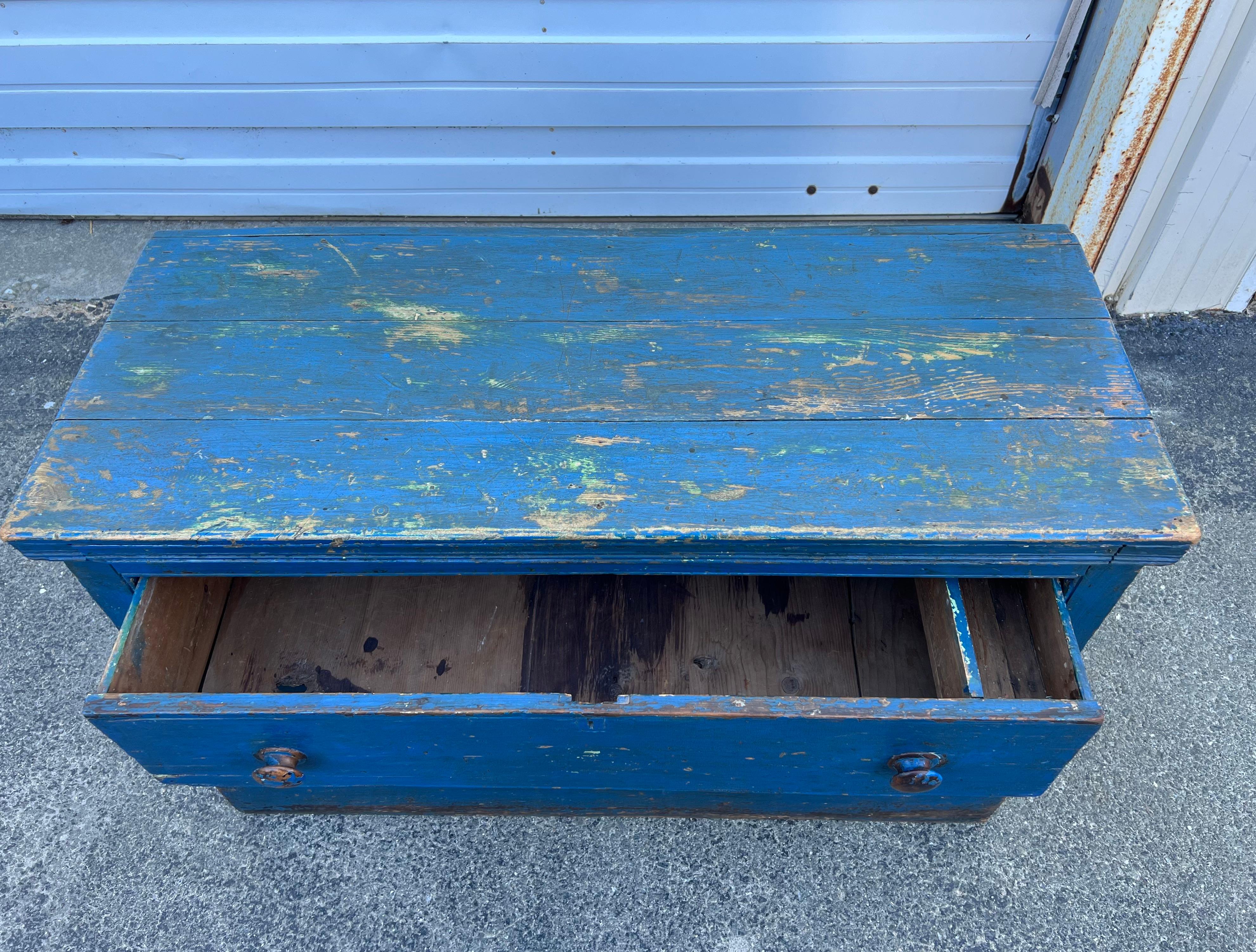19th century low chest of (two) drawers with turned wooden knobs.  Constructed from pine in original/early bright blue paint, both upper and lower drawers feature original tills.  Circa 1870, found in Nova Scotia.