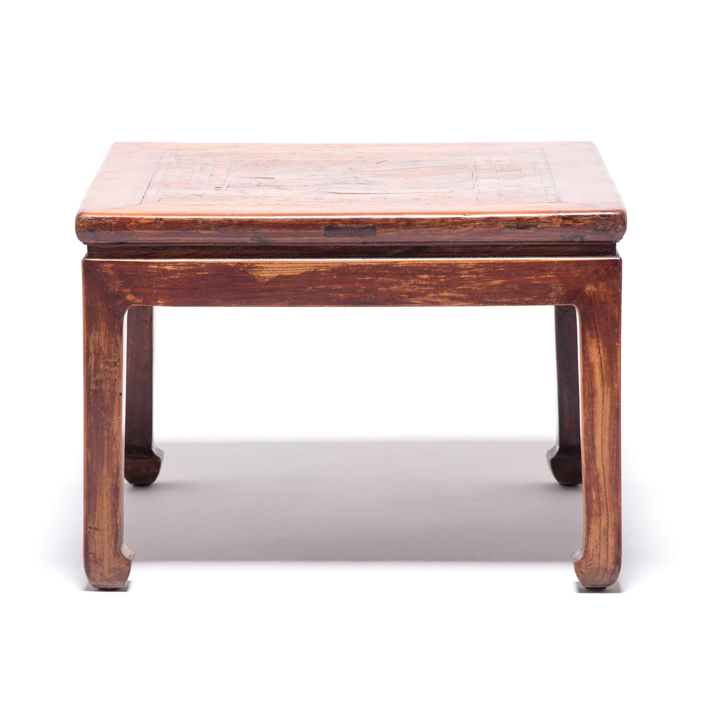 Pieced bits of wood veneer create a beautifully executed marquetry design on this special table. The intricate geometric pattern acts as a frame for a square of burled wood. Highly valued for its swirling, freeform grain, burled wood is obtained