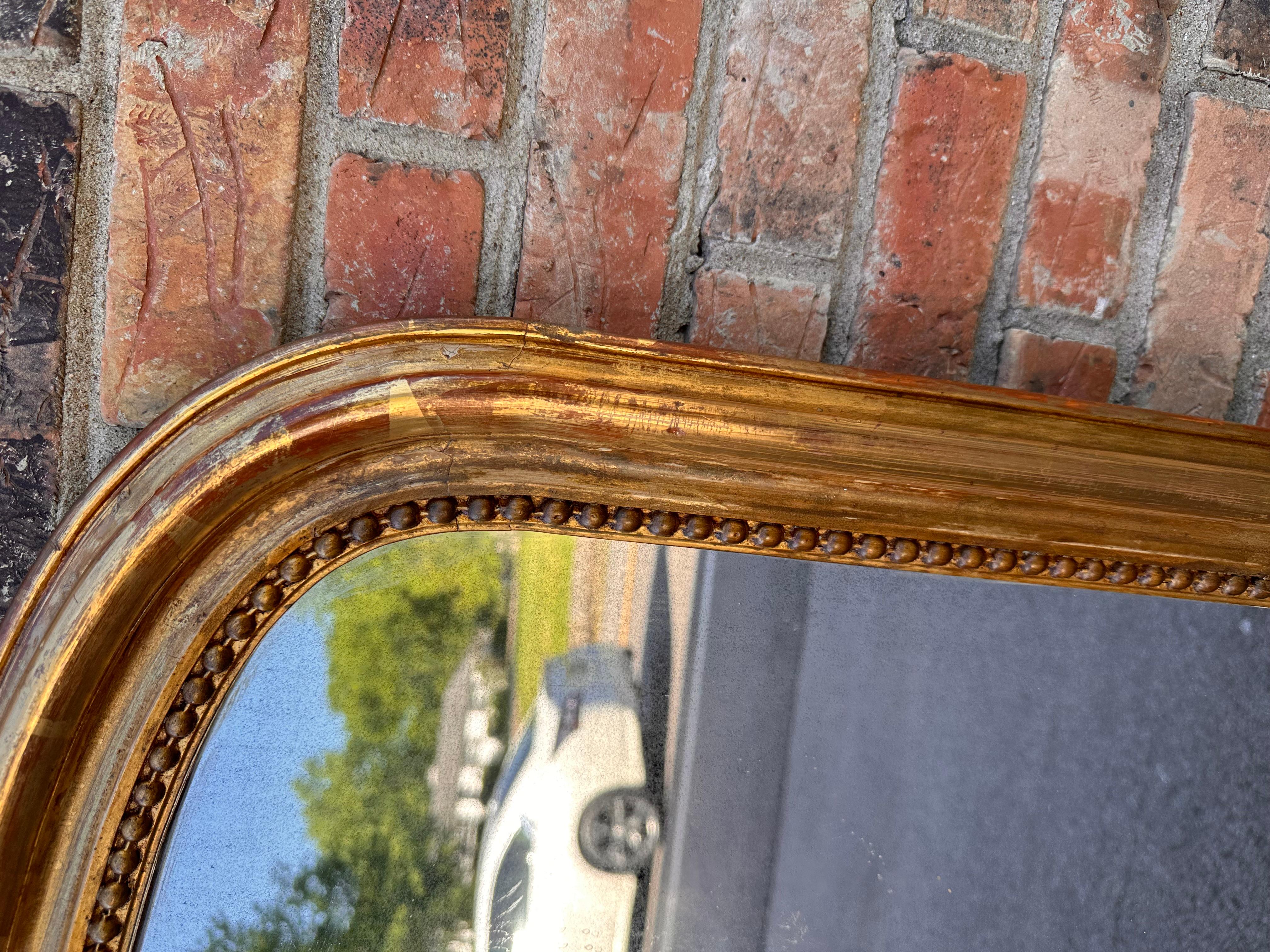 This 19th Century French mirror is top of its class! With its stunning gilded adornments such as its hand carved edging and the continuous radius of the outer edge, keeping clean lines around the perimeter. This mirror is bound to make a grand
