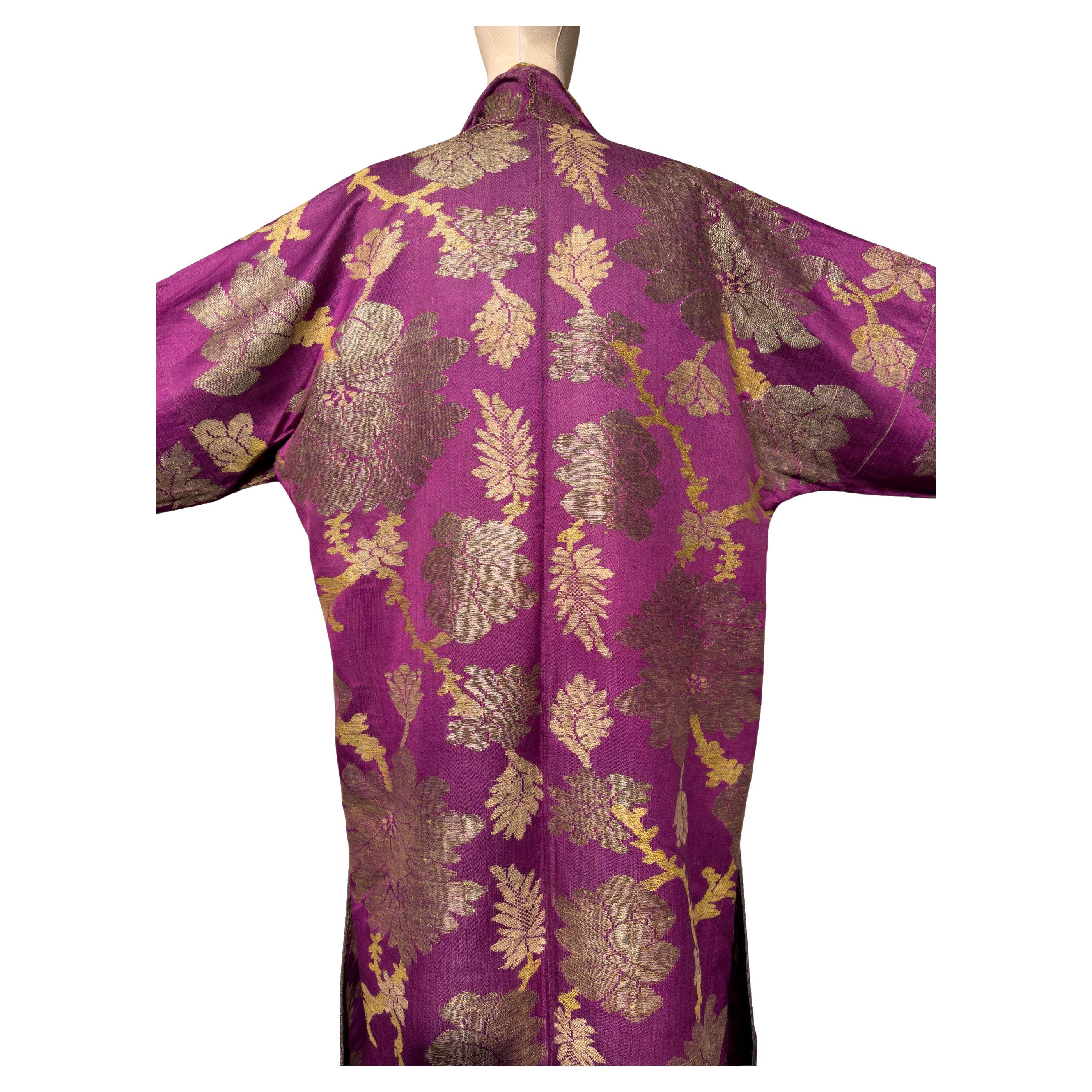 Este abrigo chapán de seda de mediados del siglo XIX muestra el refinado arte textil de Asia Central. Su exterior está tejido con un vivo brocado de seda azul zafiro enriquecido con hilos metálicos, formando un intrincado motivo de medallón