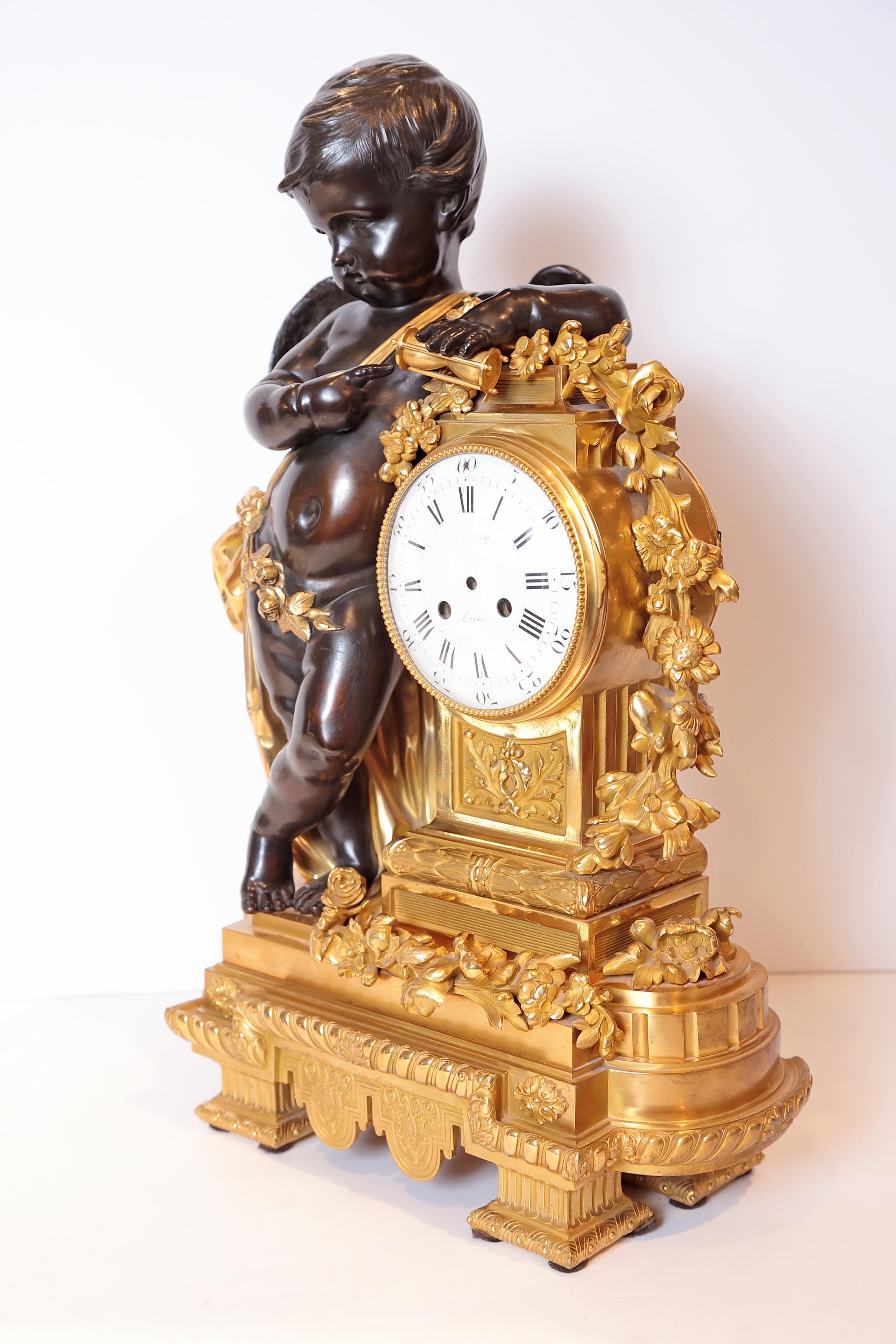 Museum quality highlighting a patinated bronze winged putti holding an hour glass, and dressed in a knotted sash with rose garland. The exquisite doré bronze clock draped with meandering flower vines. The pedestal and shaped base ornately decorated