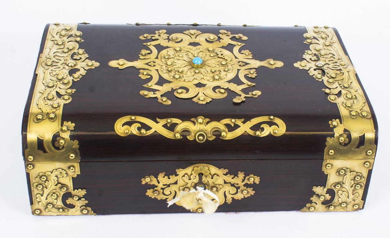 This is an elegant antique Victorian mahogany and cut brass rectangular jewelry casket, circa 1860 in date.
 
This exquisite collector's item has a hinged lid and features beautiful cut card engraved brass in Gothic style with turquoise