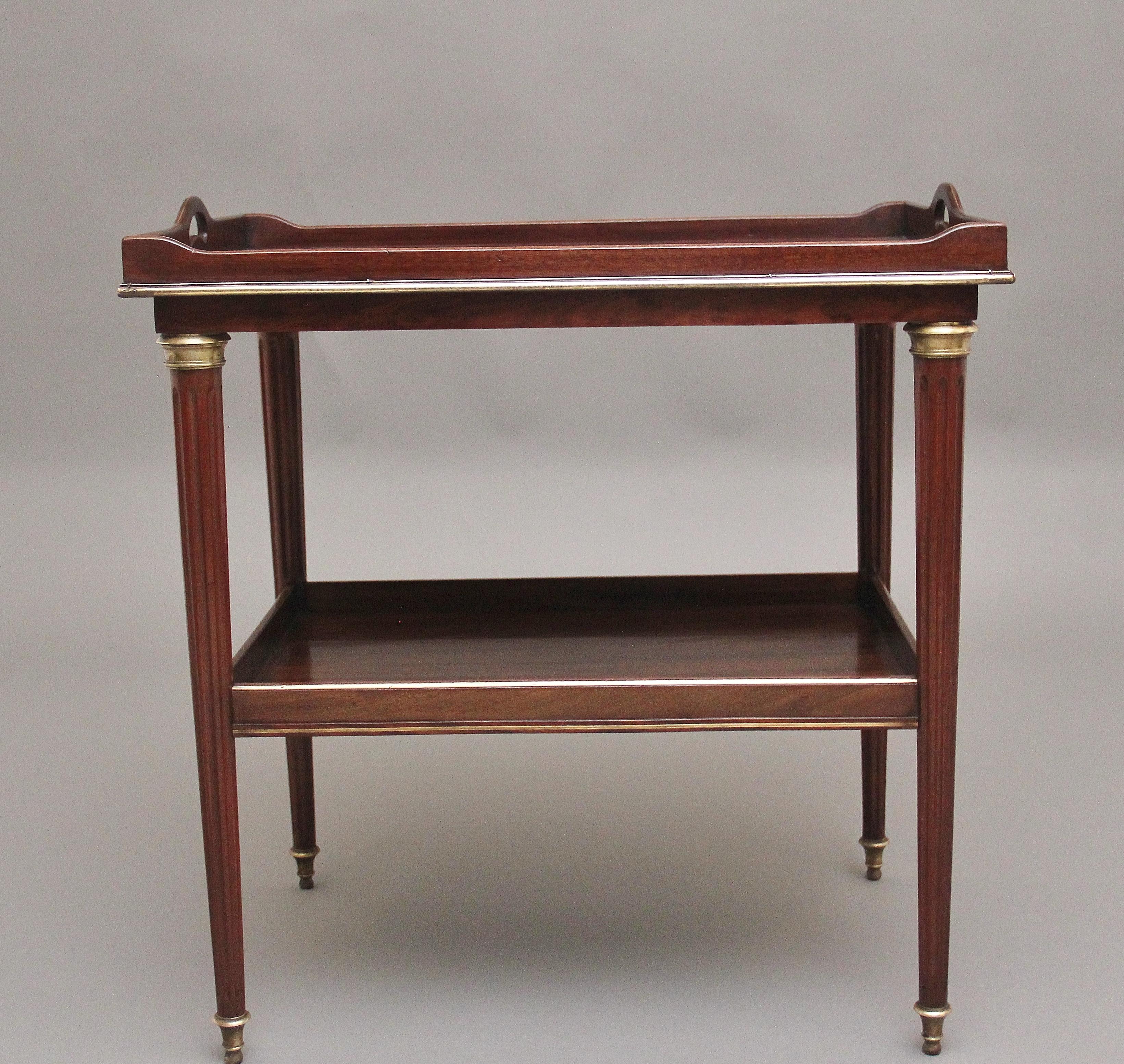 19th Century mahogany and brass side / occasional table, the rectangular and lovely figured top having a raised gallery with fret cut carrying handles at either side with pull out slides pull below, having a shelf below with a raised gallery,