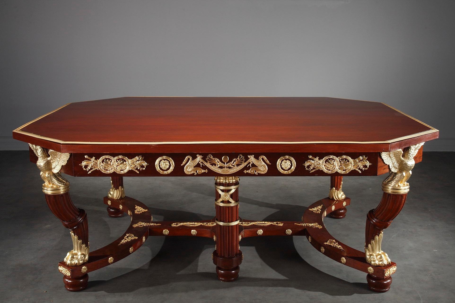 This 13-piece Napoleon III dining room suite crafted of mahogany and mahogany veneer, boasts intricate ormolu bronze decoration in Empire style. The suite features twelve chairs and a large dining table.

The octagonal table has a rich gilt and
