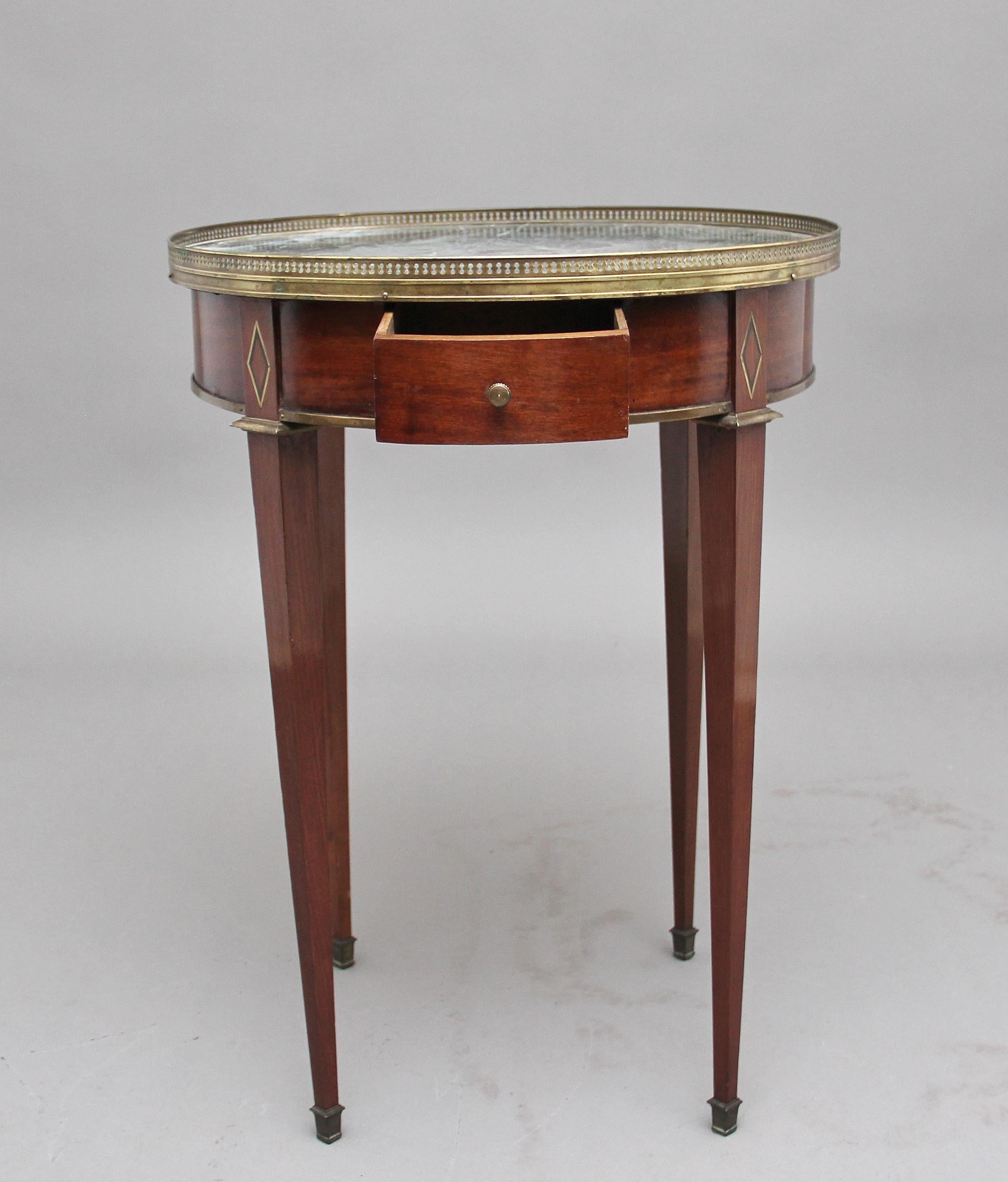19th century French mahogany and marble-top occasional table, the circular top with a pierced brass gallery with a decorative green marble insert, the apron below having an oak lined drawer at the front, standing on square tapering legs terminating