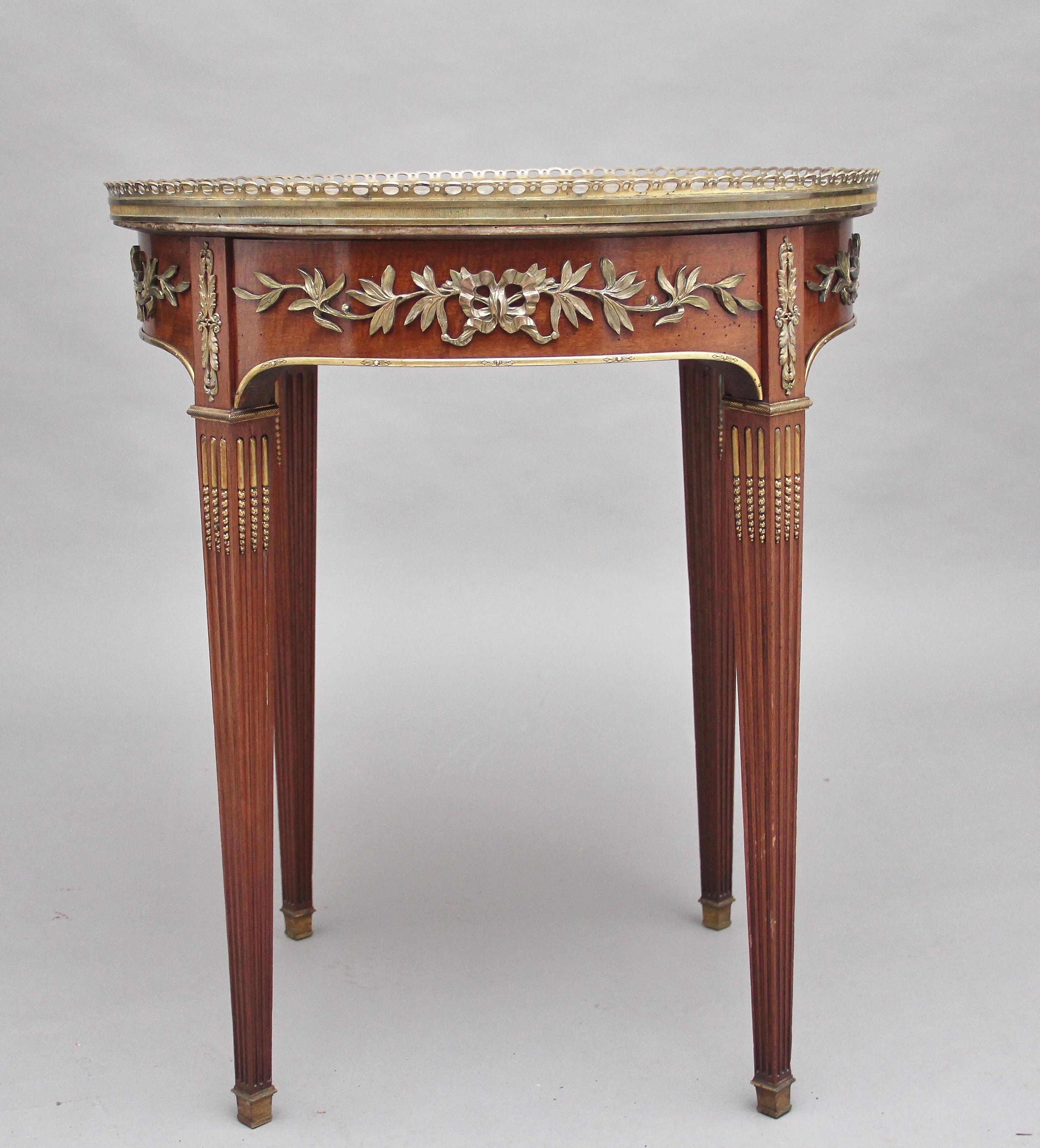 19th century French mahogany and marble-top occasional table, the circular top with a pierced brass gallery with a decorative grey marble insert, the shaped apron below decorated with floral ormolu and having a mahogany lined drawer at the front,